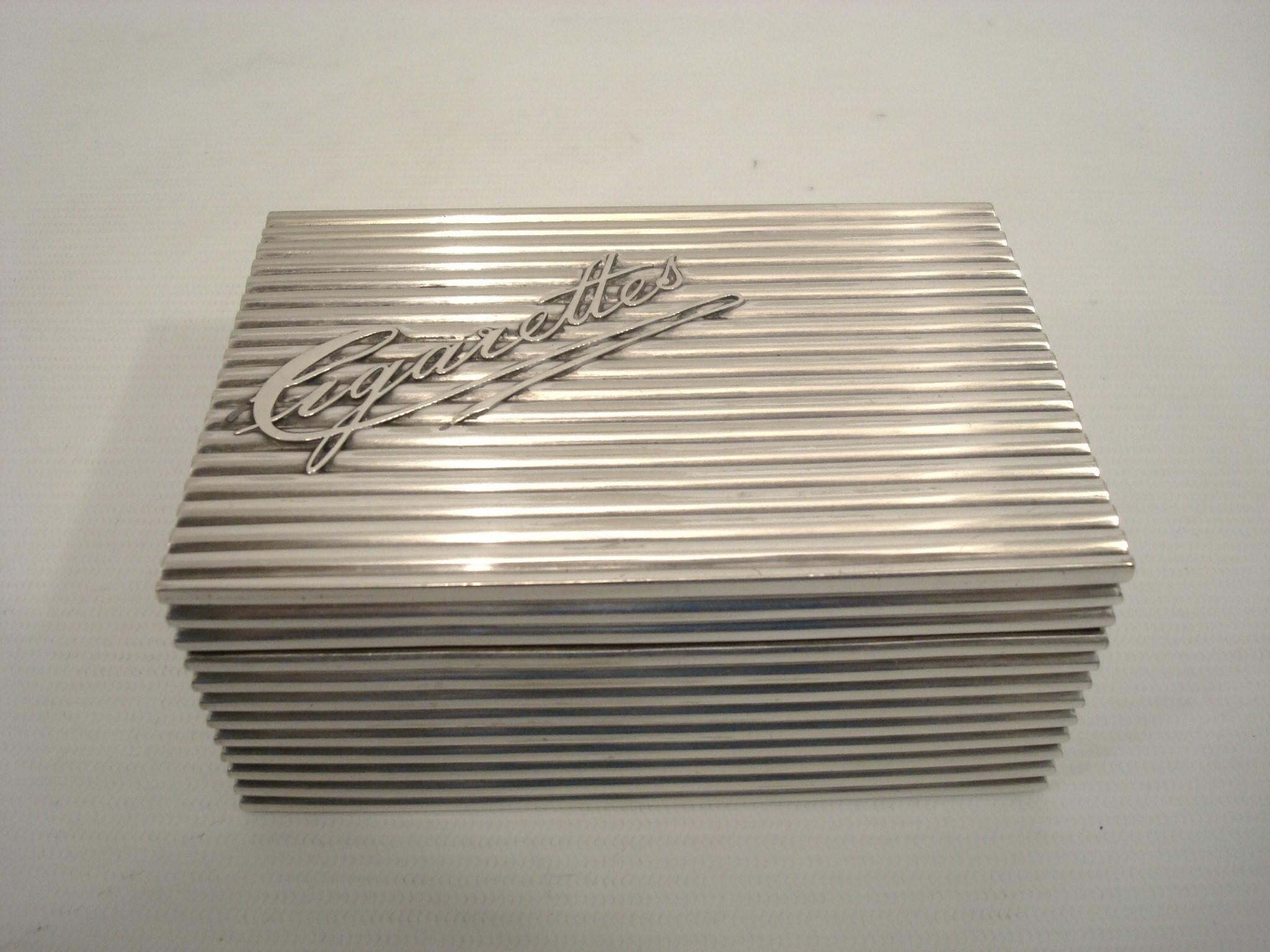 Metal case with a grooved texture. On the top of the box is written the word 