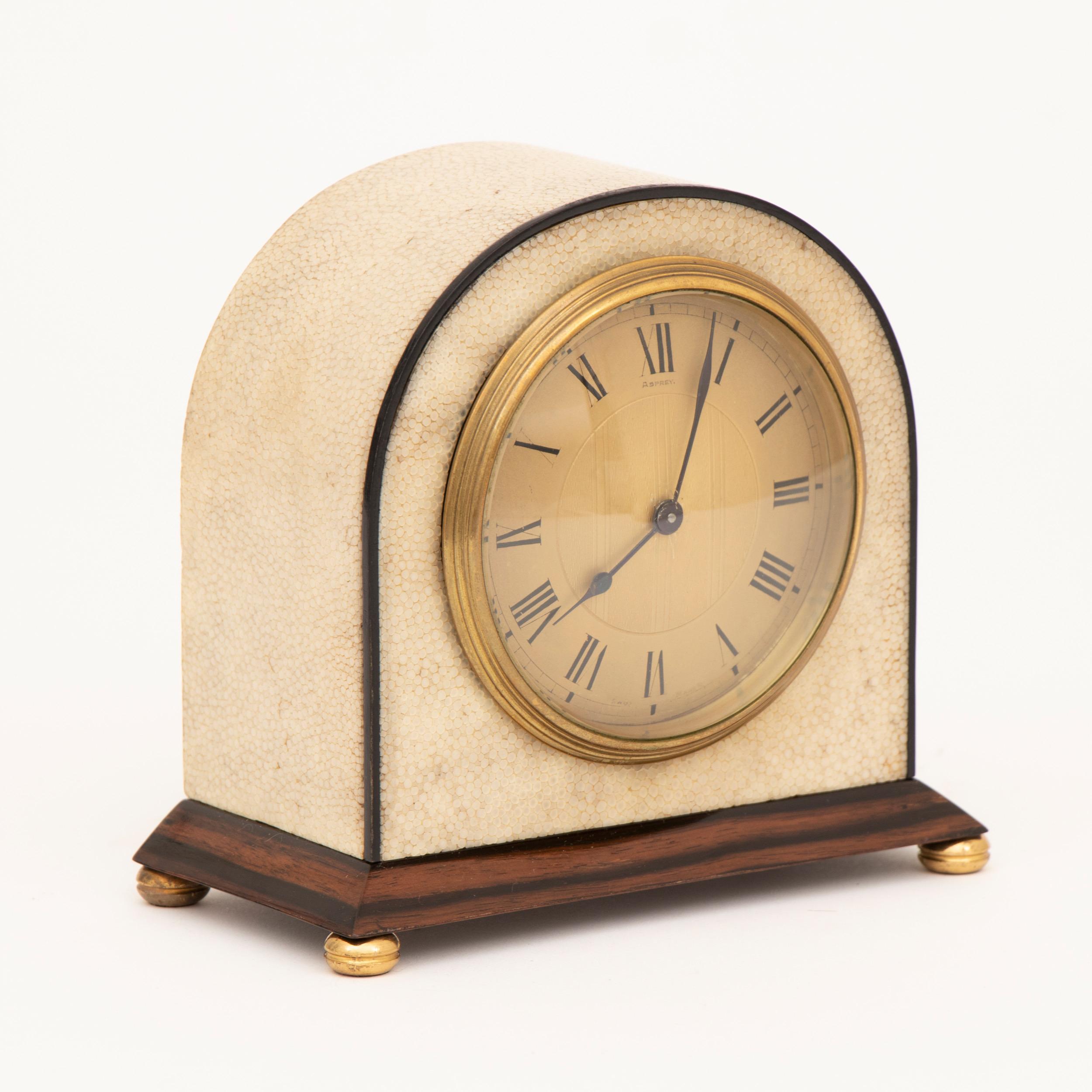 An Asprey Art Deco clock in an ivory shagreen with black edging on a polished Macassar base and a Swiss movement by Buren, circa 1920
Measures: H 14cm, W 15cm, D 9cm
Asprey, London.