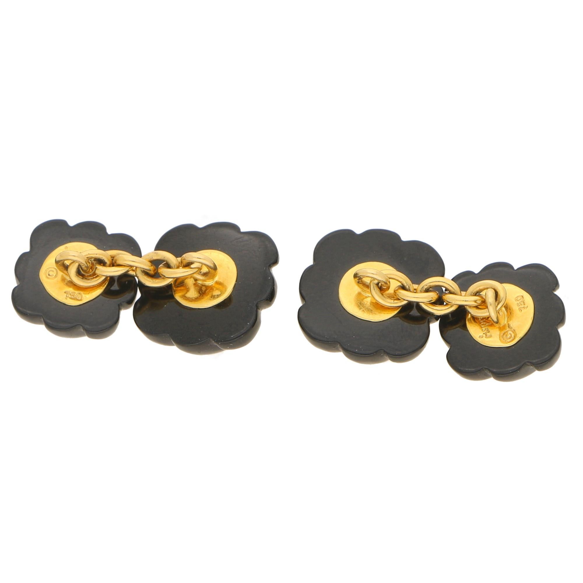 A sophisticated pair of carved onyx and diamond cufflinks set in 18ct yellow gold, signed Asprey. This interesting pair features a Celtic knot with a stylised carved onyx body embellished to the centre with a round brilliant cut diamond in a yellow