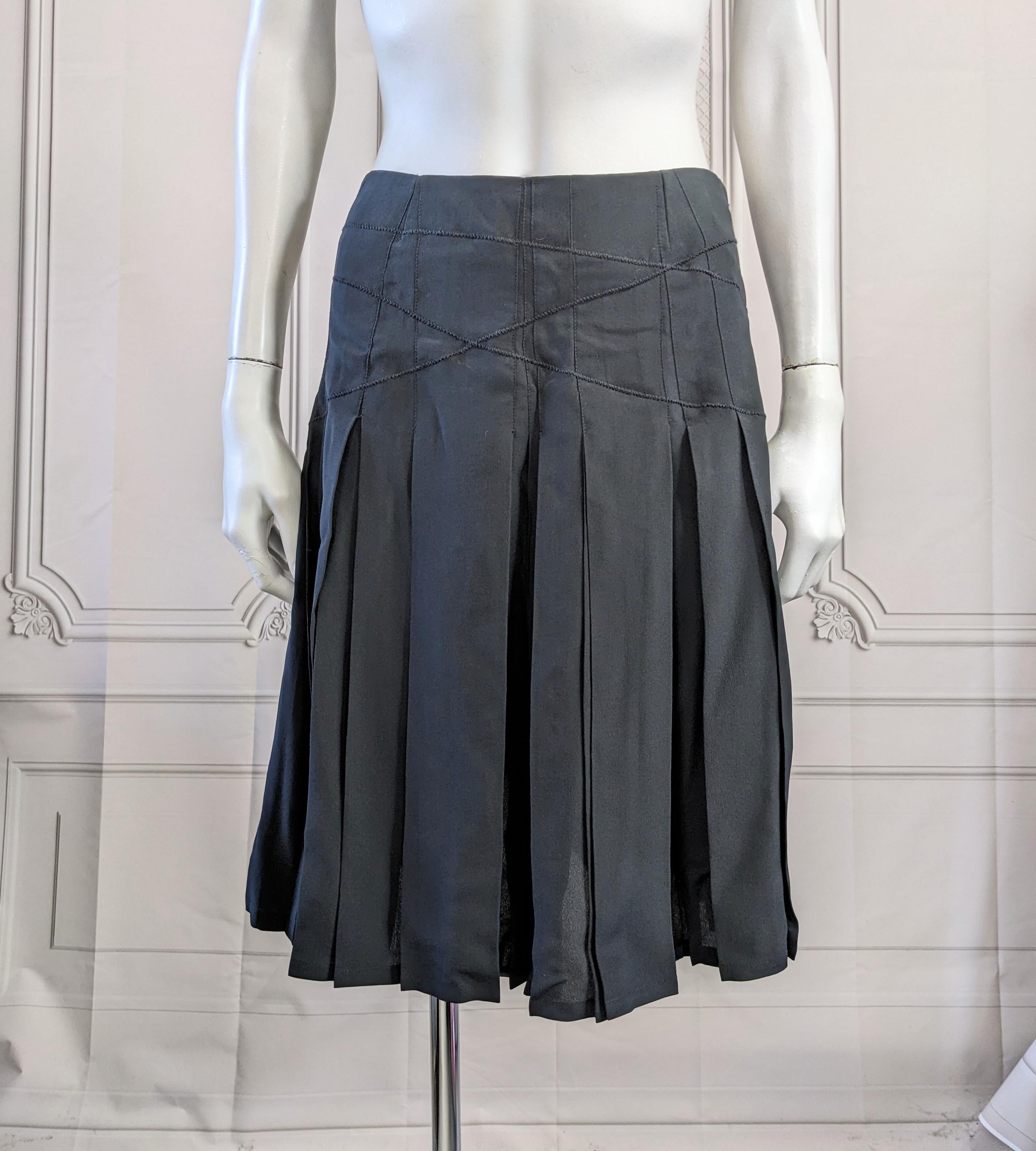 Unusual Asprey, London Black Silk Crepe Pleated Skirt. Box pleated with a series of angled pleats underneath allow for hidden fullness. The pleats are held down by random zig zag stitching across the hip area. Side zip entry. Size 4. Asprey London.  