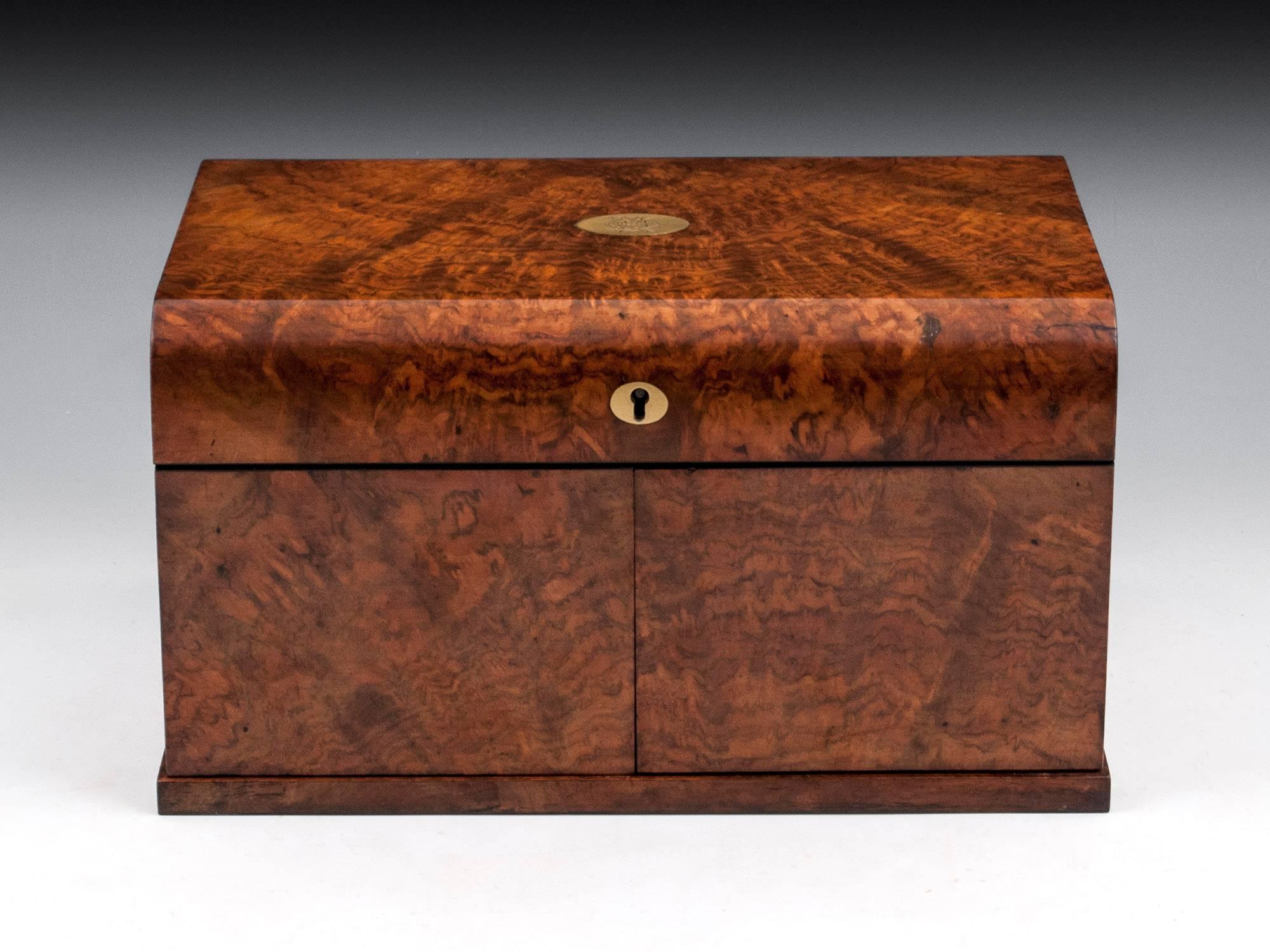 A stunning games compendium veneered in beautiful figured burr walnut with a satinwood interior and coromandel facings. The top lifts and the front doors swing open to reveal a Staunton natural and red stained bone chess set with three layers of