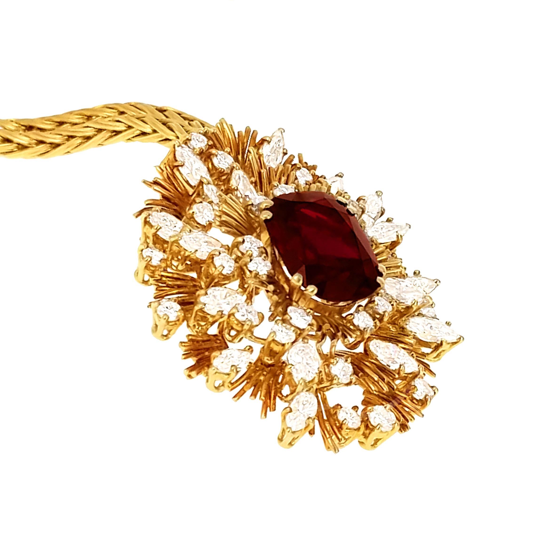 Cushion-shaped ruby and diamond abstract oval cluster pendant, the central ruby weighing 7.64 carats in a ribbed gold sunburst surround embellished with circular and navette-cut diamonds, suspended from a gold foxtail link chain.

With report no CS