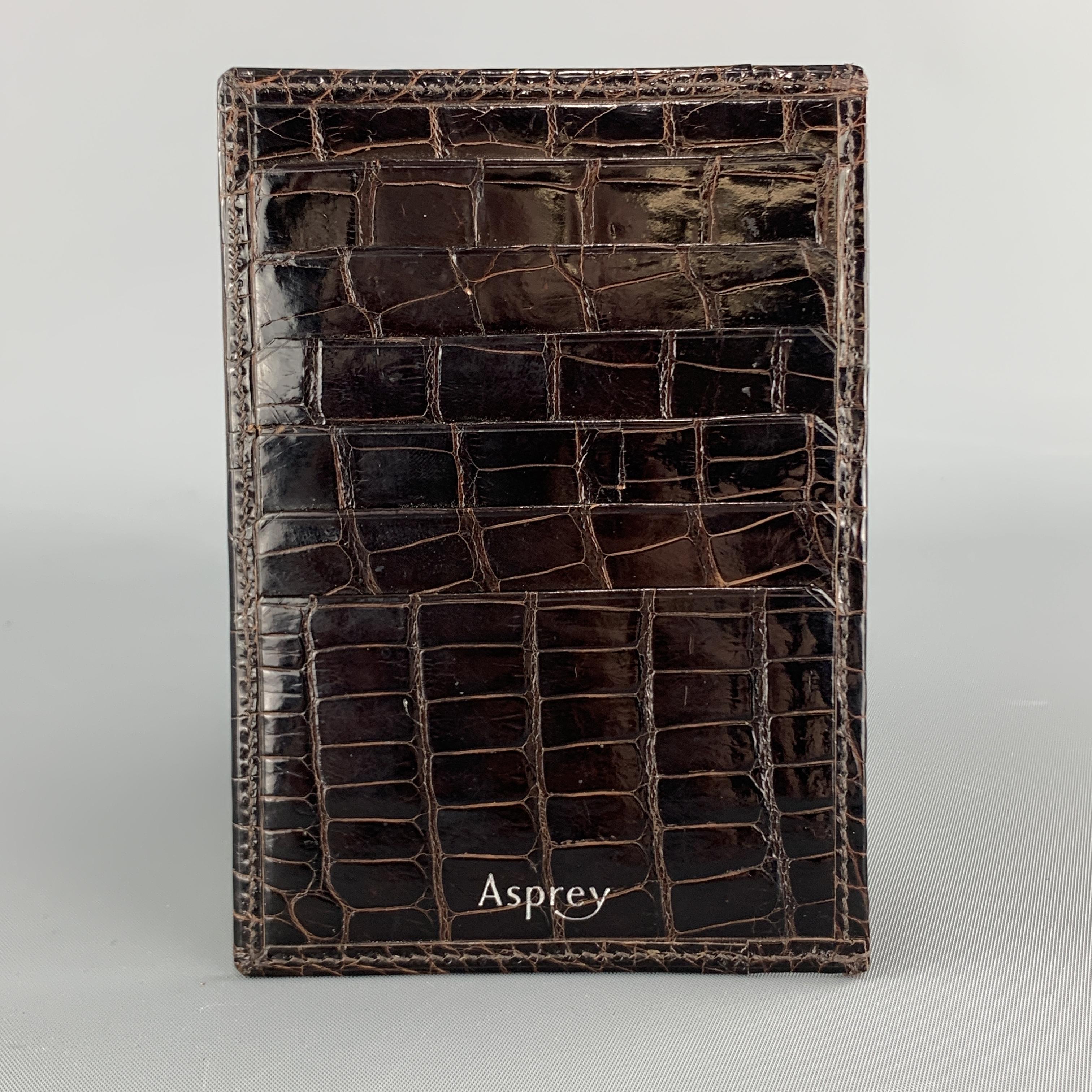 ASPREY card case comes in deep brown alligator leather with internal and external card slots. Made in Spain.

Excellent Pre-Owned Condition.
4.25 x 3.75 in.