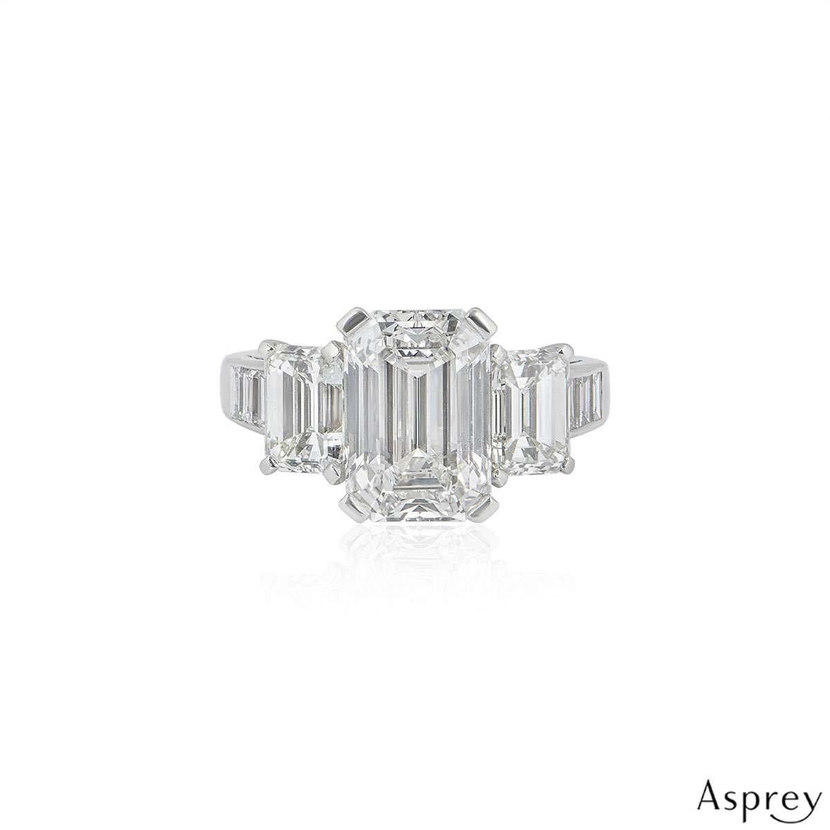 An exquisite diamond ring in platinum by Asprey. The ring is set to the centre with a 4.30ct emerald cut diamond in a classic 4 claw setting, the diamond is H colour and VVS2 in clarity. There are a further two, claw set emerald cut diamonds