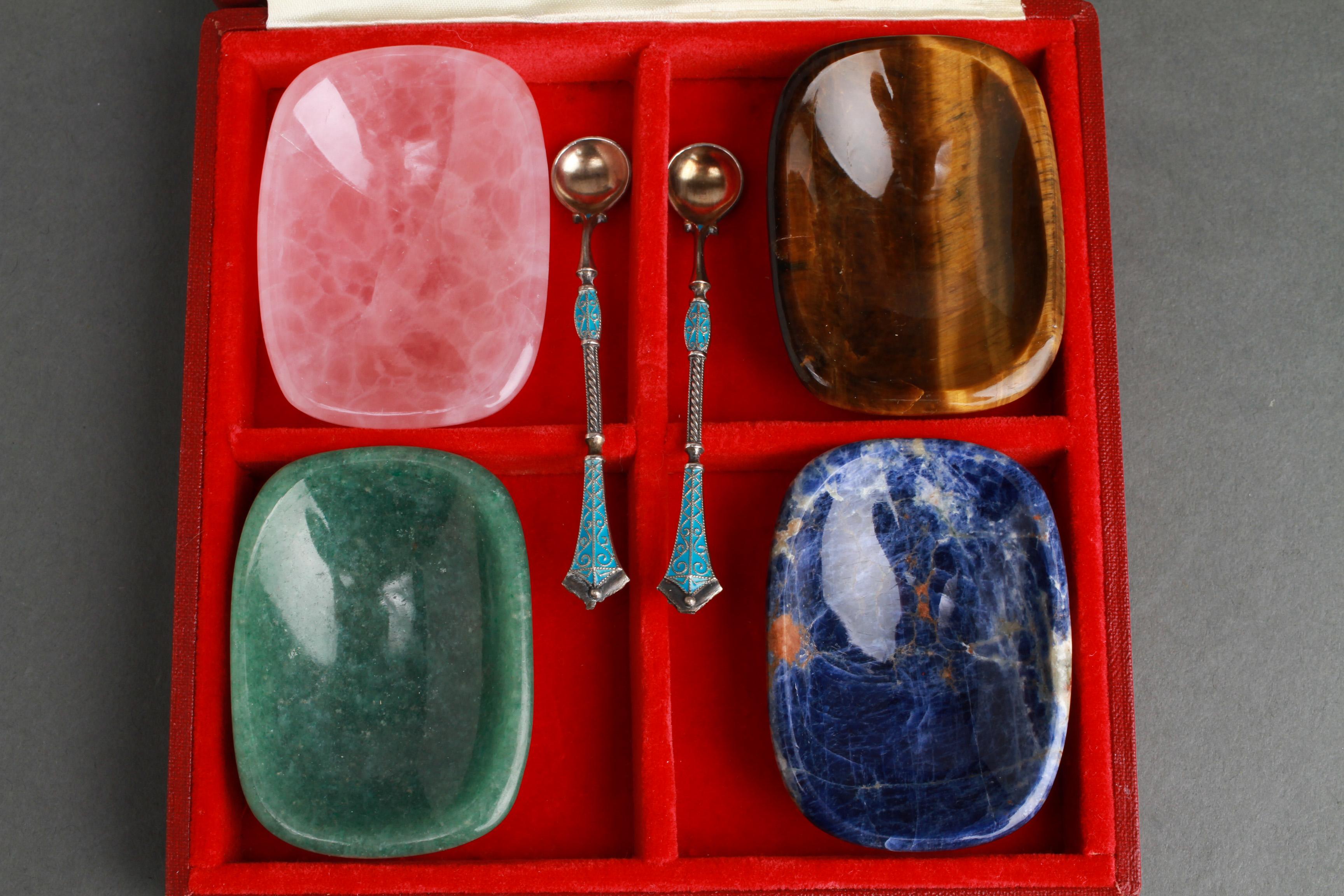 English group of four hardstone salts by Asprey & Co. The group includes rose quartz, jade, sodalite, and tiger eye, in original box. Comes with two associated English silver and enamel spoons. Salts: 2.5