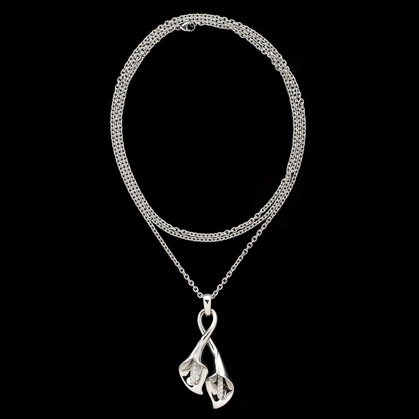 The 18k white gold pendant by Asprey is designed as a double Calla Lily, the stamens set with 24 round brilliant-cut diamonds weighing in total 0.24ct., and suspended from an 18k white gold chain. The pendant measures 2 1/8in., and the associated