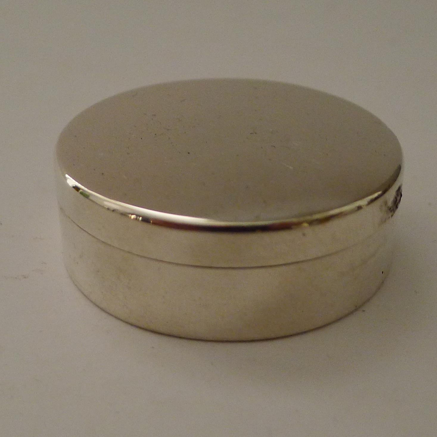 An elegant and simple lidded pill box made from solid sterling silver by the creme de la creme of silversmith's / luxury retailer's; Asprey of Bond Street.

The lid lifts to reveal a lavishly gilded interior. Both top and bottom have matching full