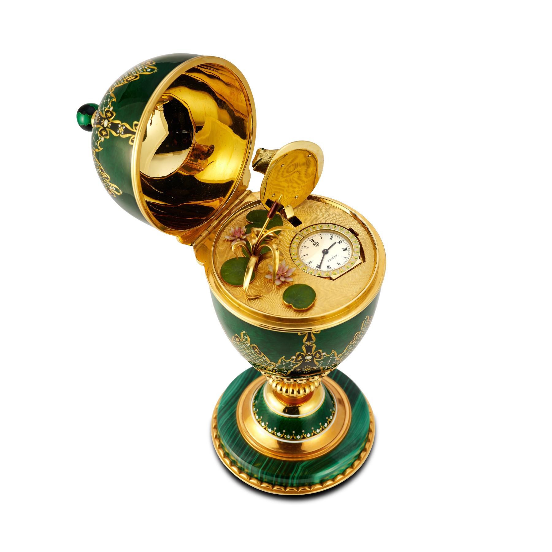 Asprey Malachite & Enamel Desk Clock

A mechanical clock made by Asprey in London in 1979. The clock is housed inside an 18 karat gold enameled egg that sits on a malachite base. When opened, the egg reveals a miniature swamp scene with lily pads