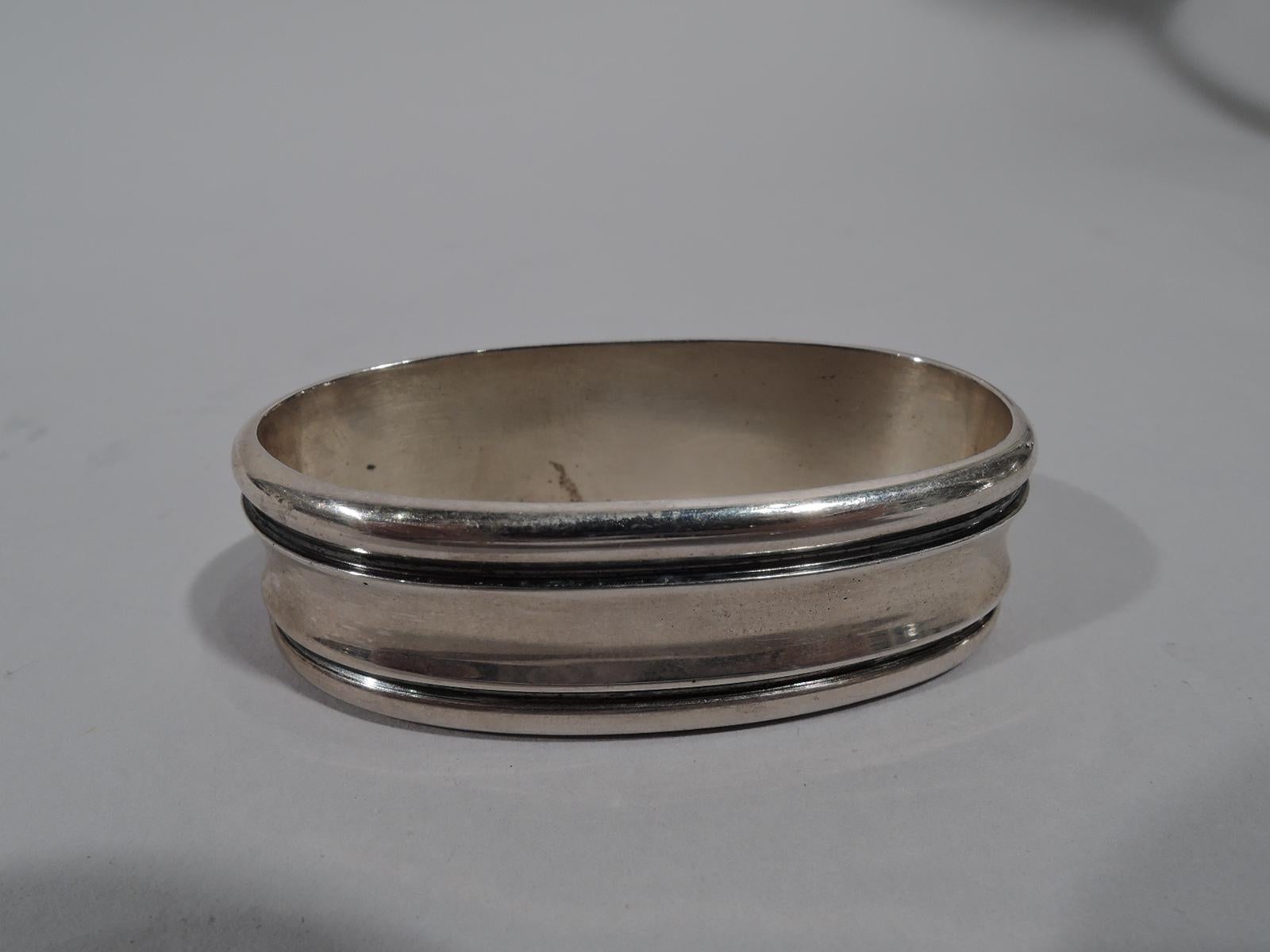 Mid-Century Modern sterling silver napkin ring. Oval with wrapround concave band. Marked “Asprey Sterling”. Weight: 1.2 troy ounces.