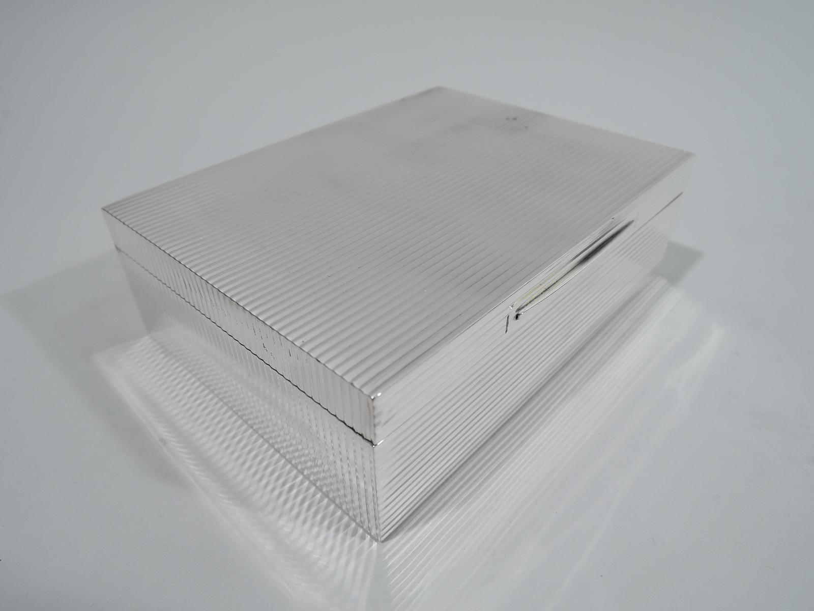Smart and Modern sterling silver box. Made by Asprey in London in 1960. Rectangular with straight sides. Cover flat and hinged with tapering tab. Front, back, and top have horizontal ribbing. Sides have vertical ribbing. Box interior cedar lined.