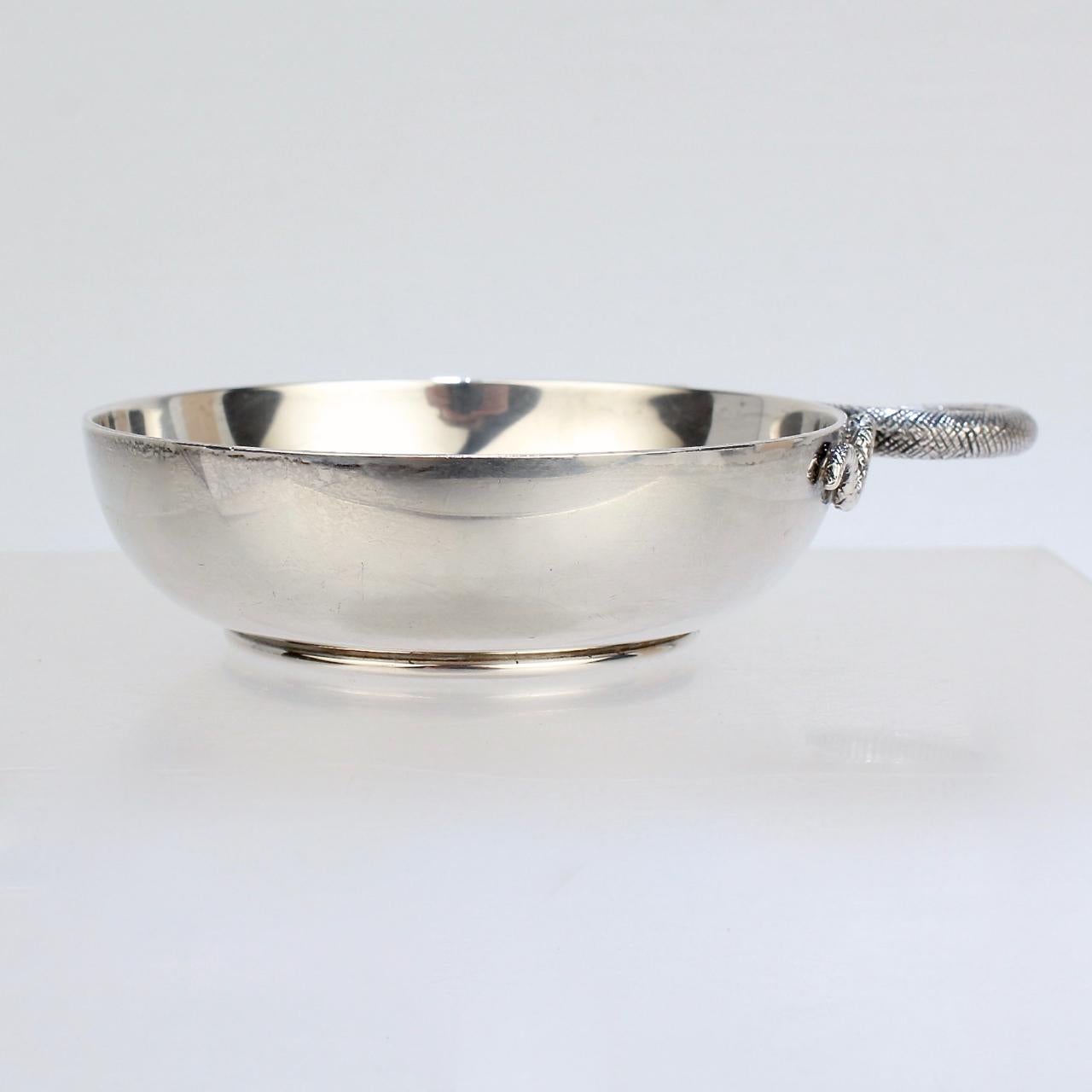  A vintage Asprey sterling silver “tastevin” wine taster - a shallow cup traditionally used by winemakers to taste (and judge) wine.

With a traditional stylized coiled snake handle.

Simply a wonderful piece of silver for any wine enthusiast from