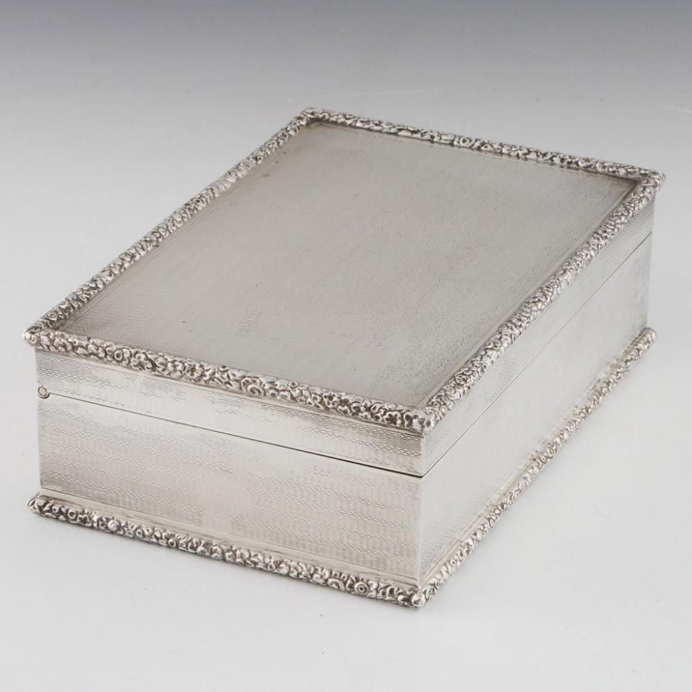 Heading : Sterling silver table cigarette box
Date : Hallmarked in London in 1961 for Asprey & Co.
Period : Elizabeth II
Origin : London, England
Decoration : Embellished with machined decoration with cast floral rims. Internally parcel gilt. The