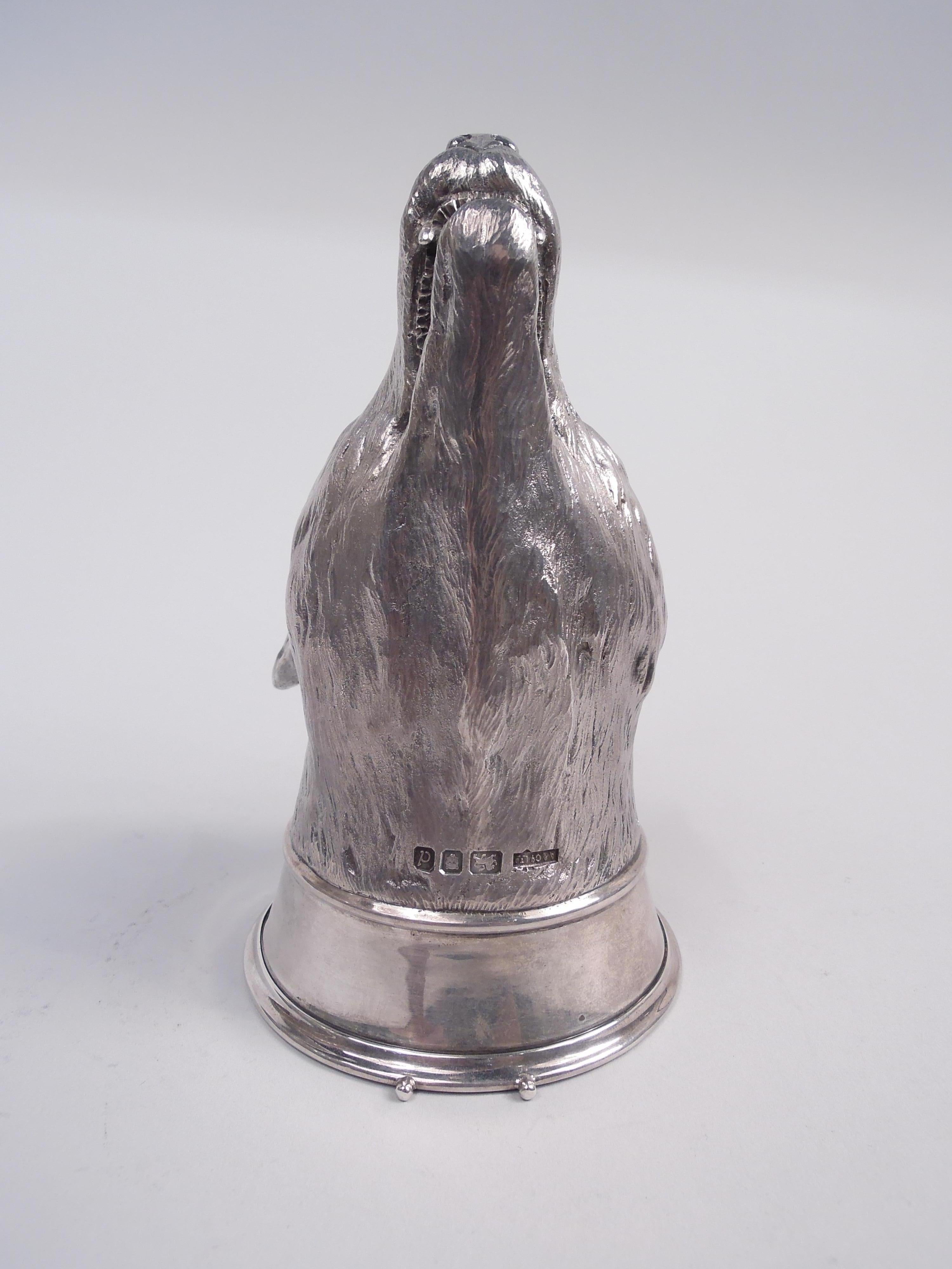 Traditional English sterling silver stirrup cup, 1959. Cast fox head with flexed-back ears, close-set eyes, and long snout; gaping mouth reveals prominent canine teeth. A portrait of vulpine cunning. Plain collar. Fully marked including maker’s