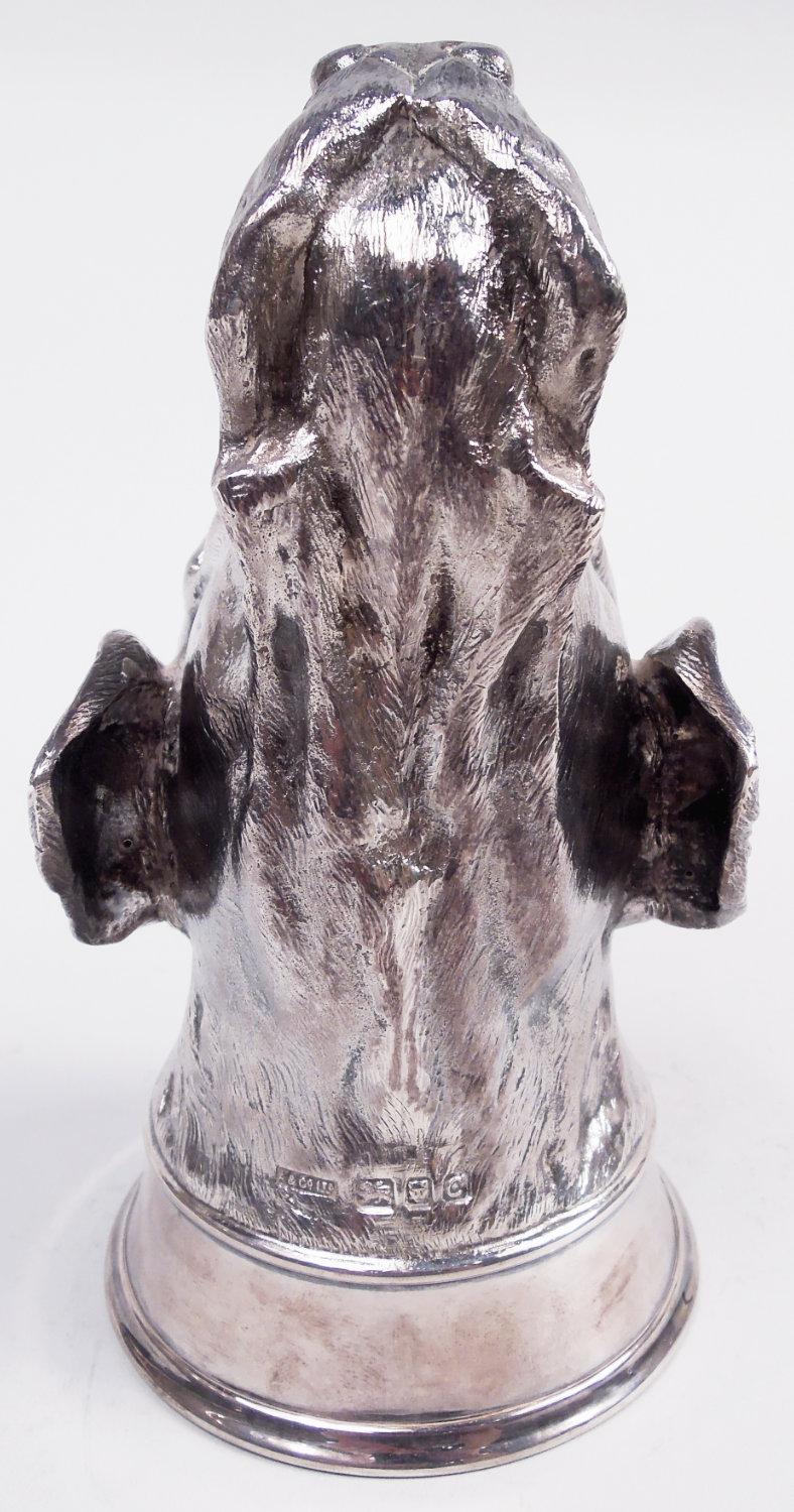 Traditional English sterling silver stirrup cup, 1958. Cast bowl in form of hound head with floppy ears, saggy jowls, and long snout terminating in prominent nostrils. Wide handspan required. Fully marked including maker’s stamp (Asprey & Co. Ltd)