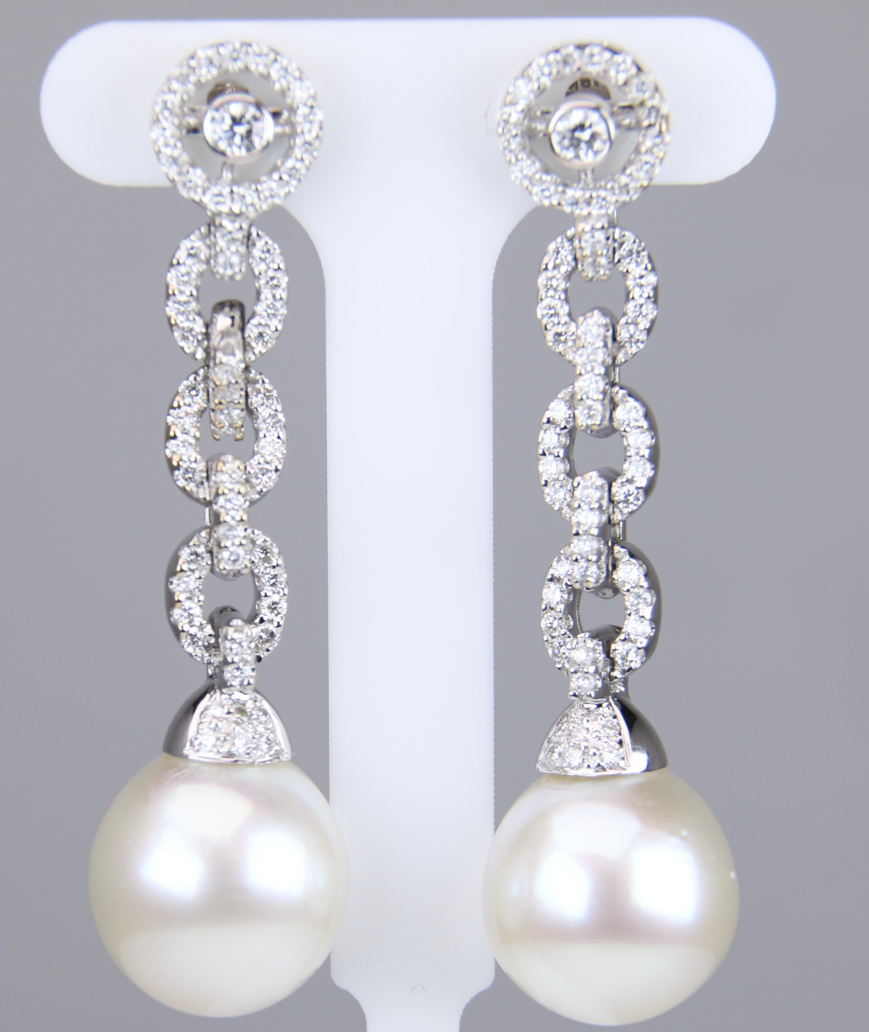 18 karat white gold South Sea pearl posts earrings.  The earrings feature 12.3mm white south sea pearls, AA quality. There are .98 carat total weight of round brilliant cut diamonds, G in color and SI1-2 in clarity.  The earrings are 1.75