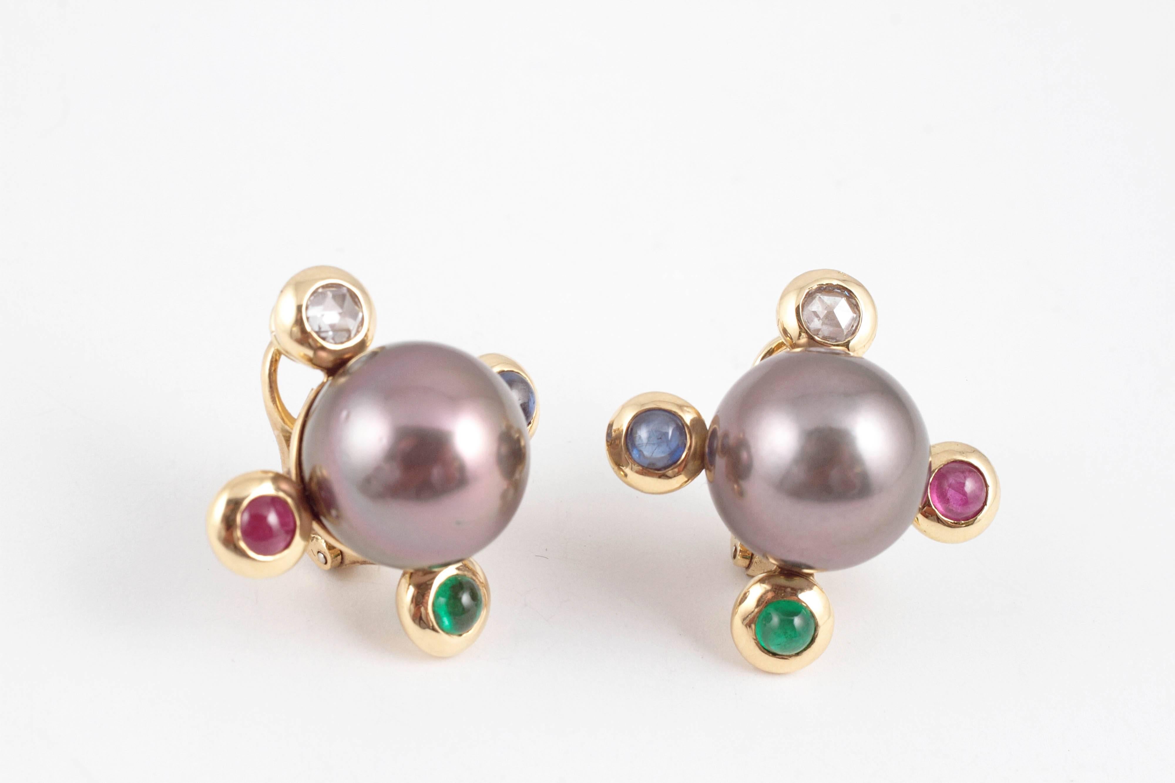 Looking for something unusual?  These 18 karat yellow gold, 14.00 mm natural color, Tahitian cultured pearl earrings are just the ticket! They have 0.50 cts of diamonds, 2.10 cts of sapphires and rubies and emeralds on each corner.  You will