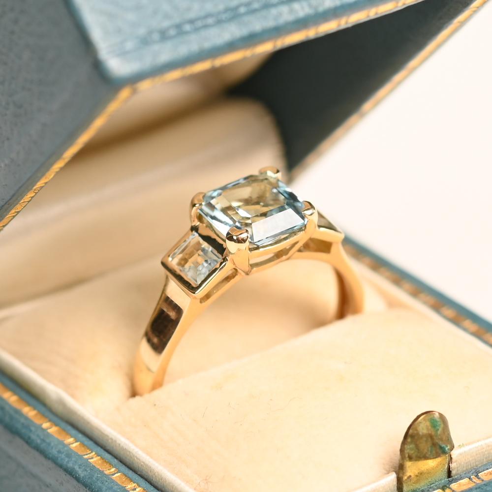 Dieser exquisite Ring aus 18-karätigem Gelbgold wird von einem fesselnden Aquamarin im Asscher-Schliff von ca. 1,20 Karat getragen. Die geometrische Präzision des Steins und sein sanfter blauer Farbton werden durch die klaren Linien der Fassung