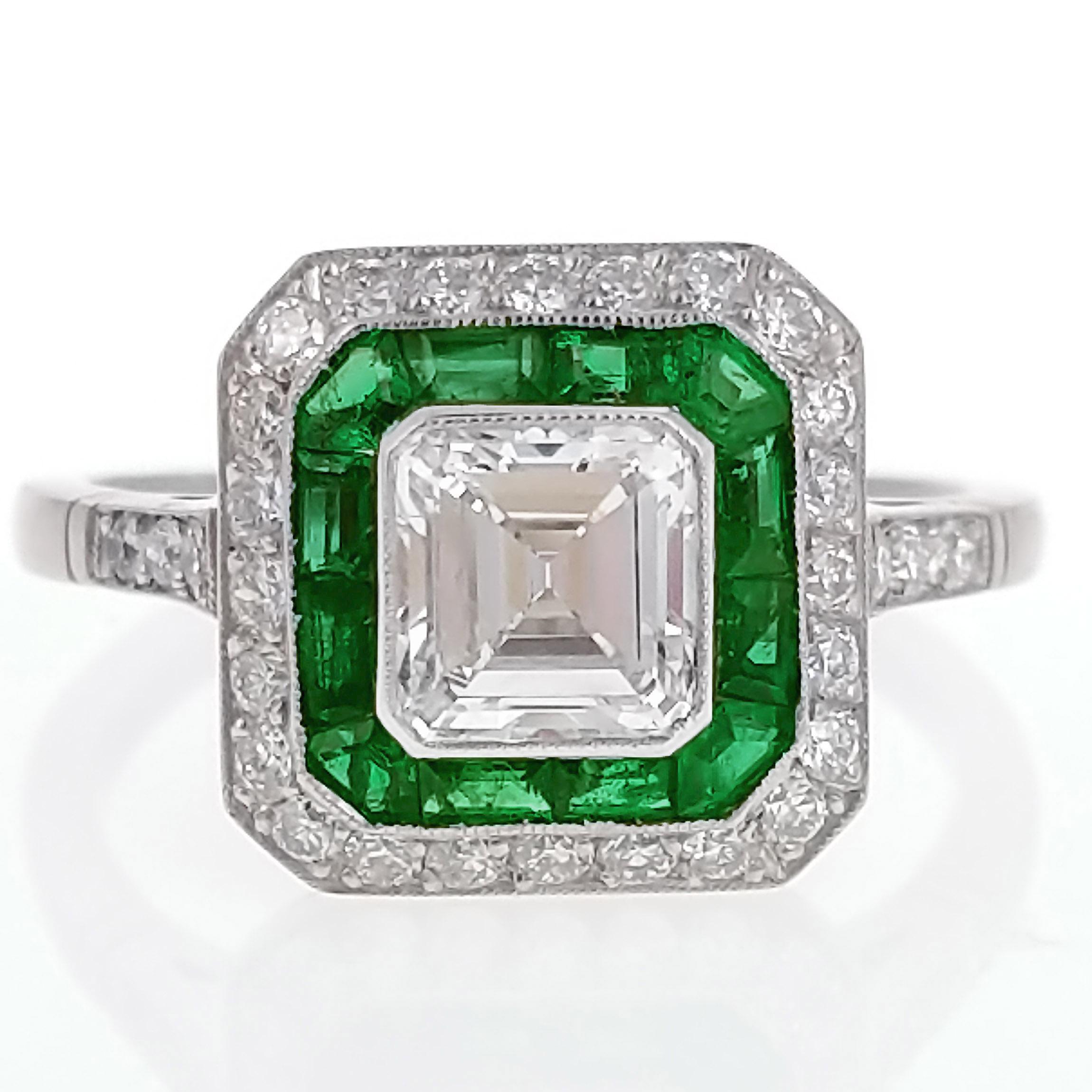 This Art Deco style ring features a 1.03 asscher-cut diamond with a surround of lively calibre-cut emeralds. It is further set by a halo of old-European cut diamonds for an additional weight of approximately .3 carat. The ring is expertly crafted in