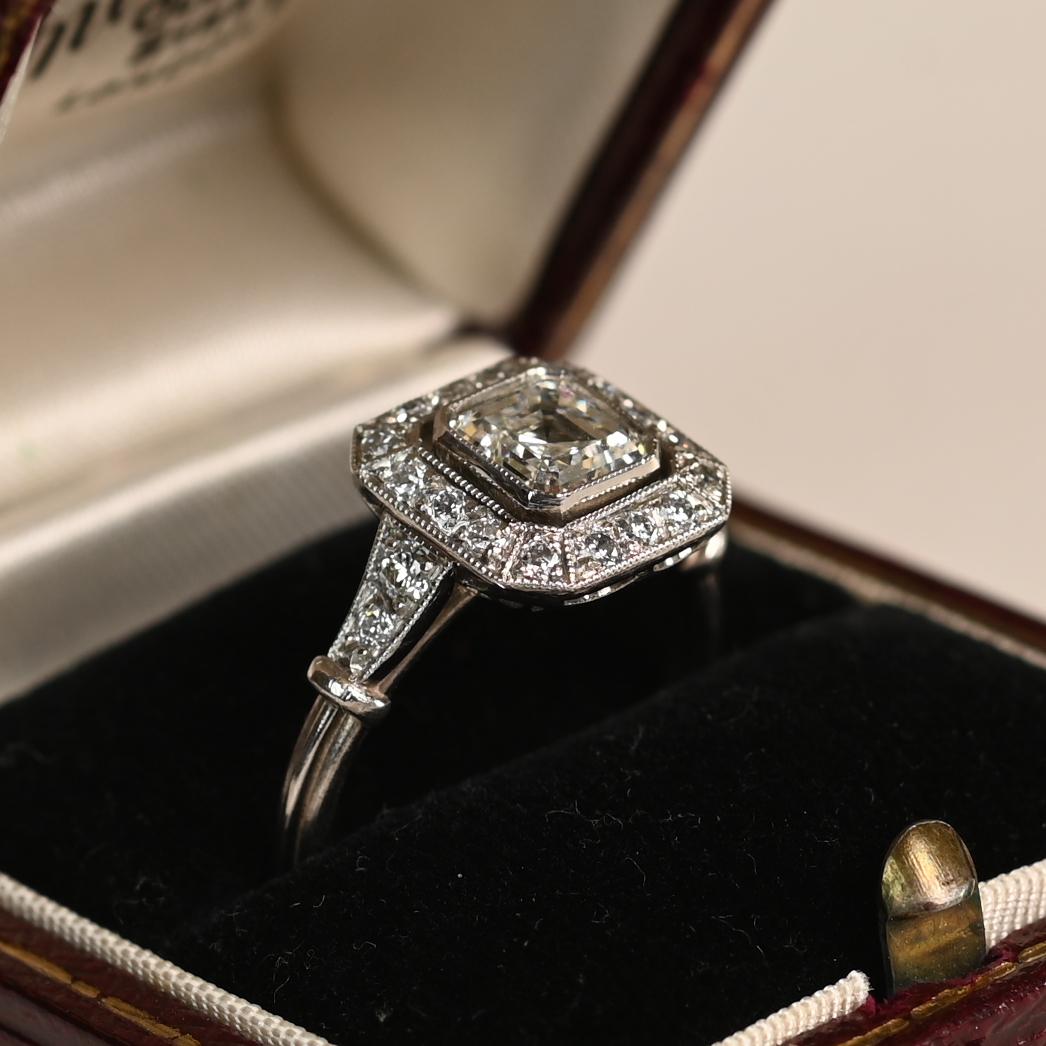 Este exquisito anillo de compromiso con halo exhibe un diamante talla Asscher de 1,01 quilates certificado por el GIA, de color J y claridad VS2. Enmarcando la piedra central hay un delicado halo de diamantes acentuados, que añaden aproximadamente