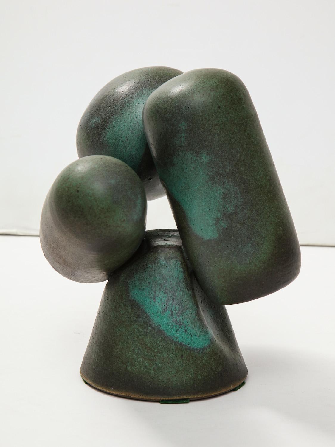 Three, wheel-thrown closed forms floating on a central cone base. Green glazes with textured surfaces. Artist signed on underside.