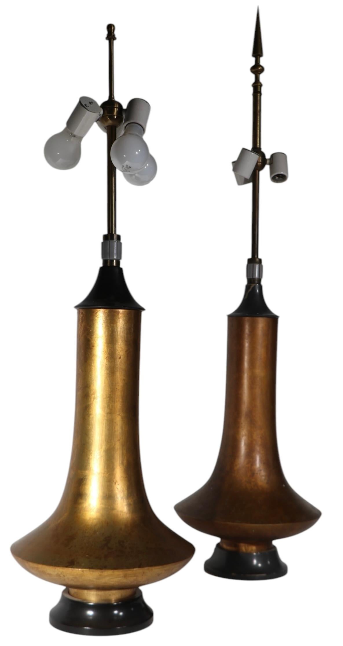 Two Brutalist, Oriental school table lamps, designed by Damon Giffard for the Hansen Lighting Company c. 1970's. The lamps feature Chinese style brass, or copper, bodies, on  wood plinth bases. Both have the signature three way rotating cuff on/off