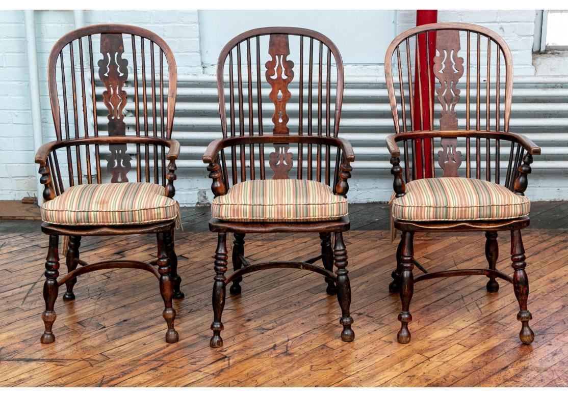 An exceptional set of timeworn Windsor Armchairs with fine aged patina. Carved oak Windsor chairs, the hoop backs with cylinders and openwork carved splats. U shaped backs into the arms with turned supports. The shaped seats raised on splayed turned