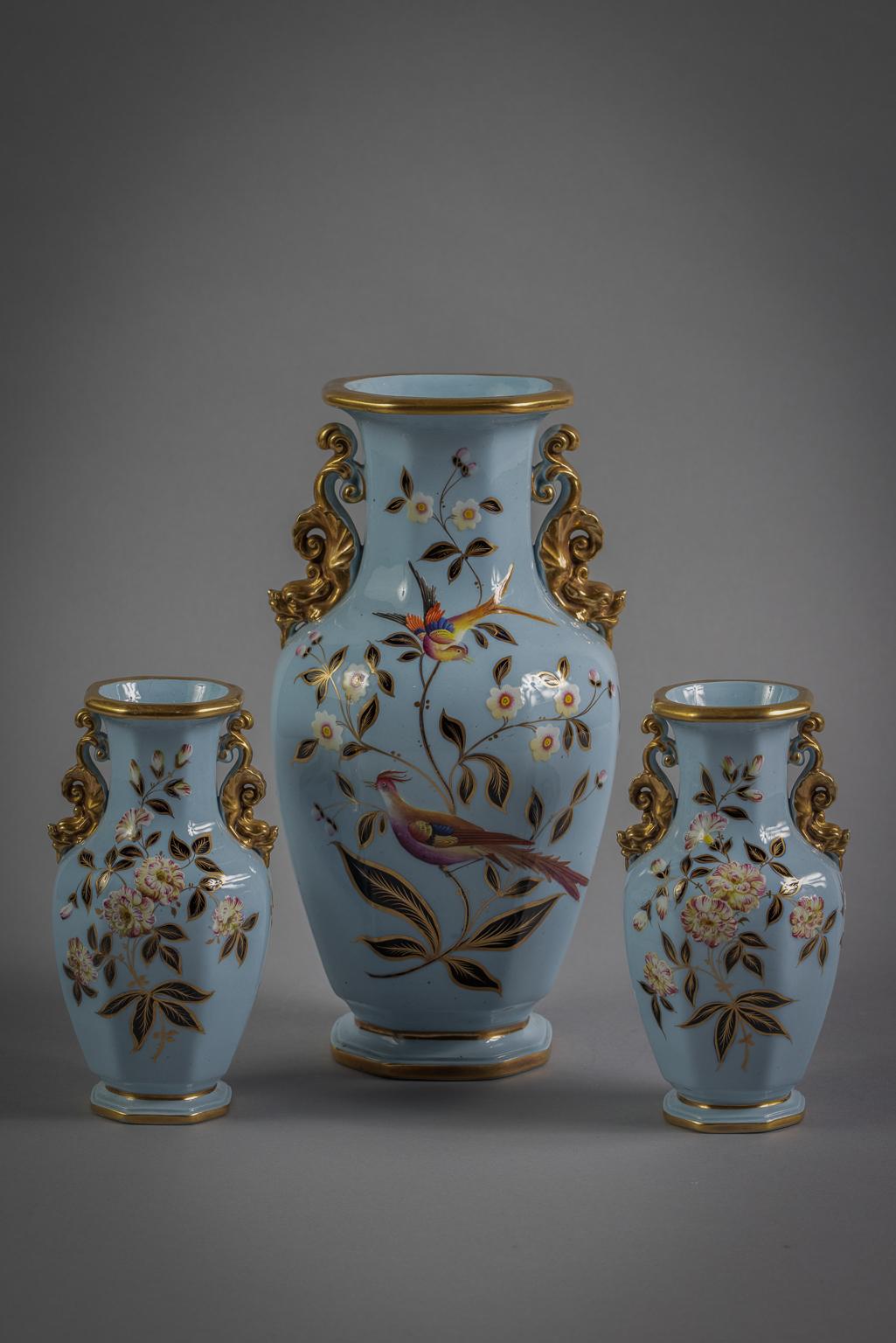 With gilt scroll handles terminating with a fierce foo dog mask, the central vase with perched birds on an aqua blue ground, the smaller pair similarly decorated minus the birds. Dimension of smaller vases: Height 6.25