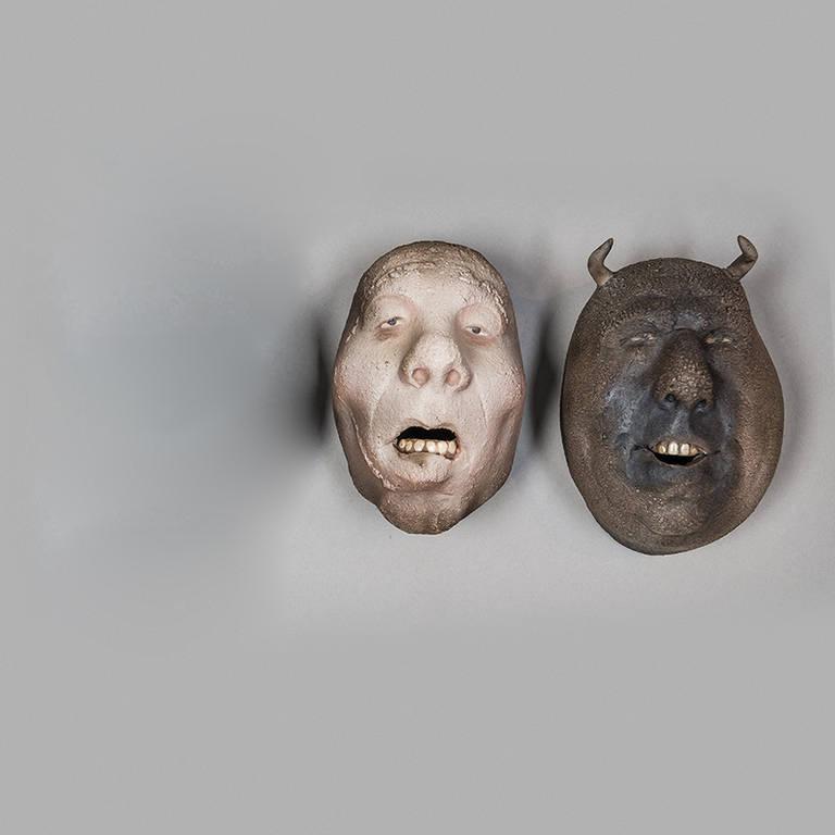 Assorted Raku fired faces, all with their own expressions, happy or sad, strong and sure, tragic or comic, by Johan Thunell. Raku is a pottery technique in which pots are raw-glazed at a low temperature then taken red-hot from the kiln and plunged