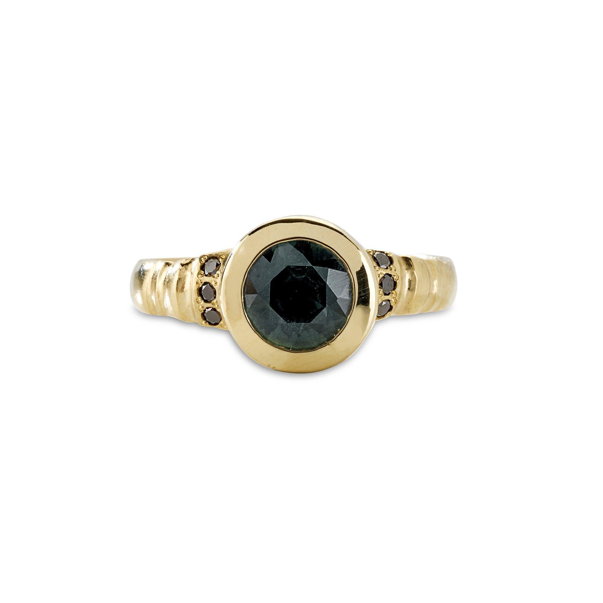 Assuan Ring, 18 Karat Yellow Gold with Australian Teal Sapphire and Black Diamond
Handcrafted and individually cast in solid gold. Olivia carves each piece from wax, making these items unique, which we believe is what gives them their beauty. The