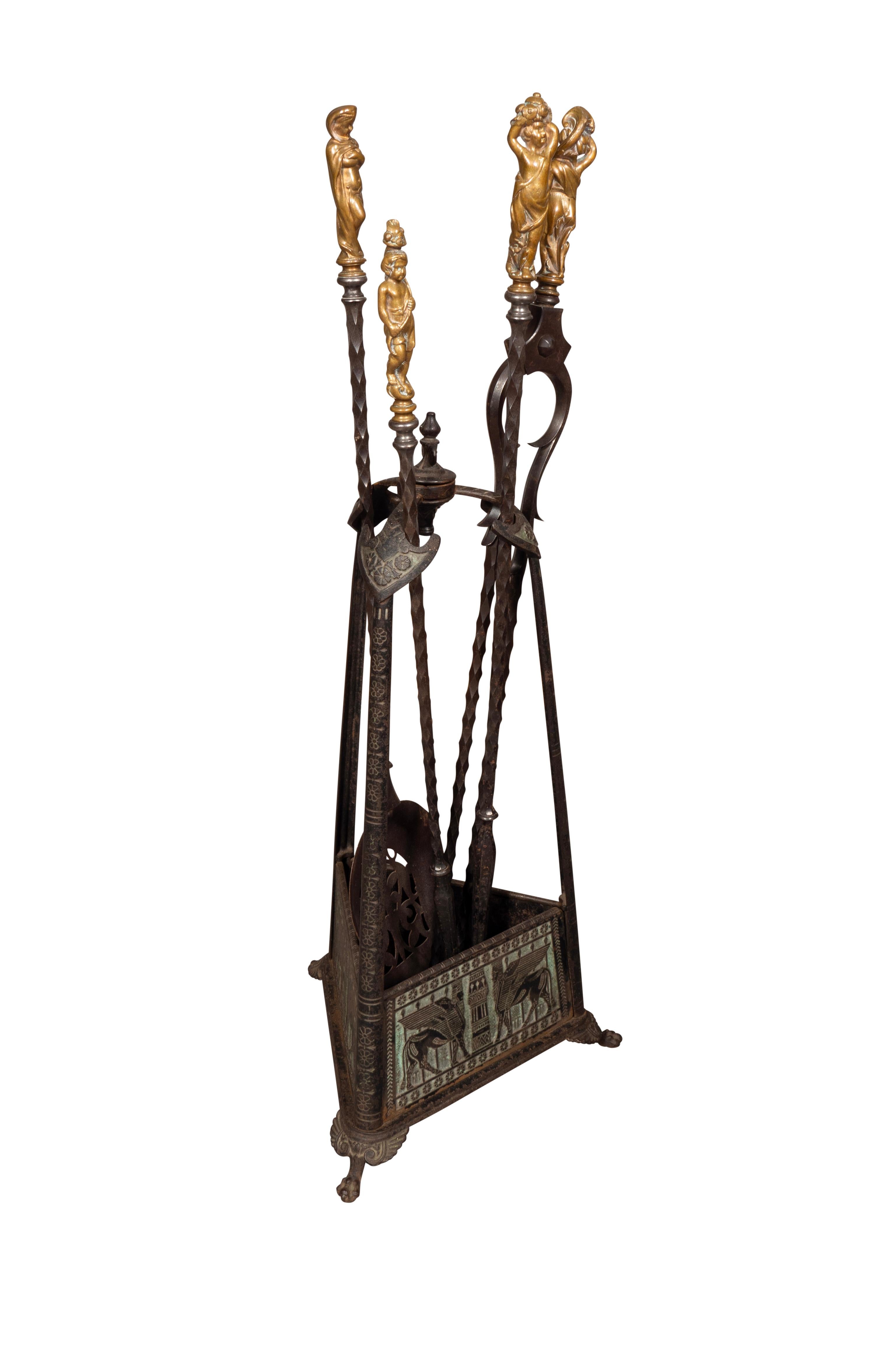 Der Halter mit assyrischem Lamassu-Dekor. Die Werkzeuge sind im Renaissancestil gehalten und mit figuralen Griffen versehen. Bestehend aus zwei Schürhaken, einer Schaufel und einer Zange.