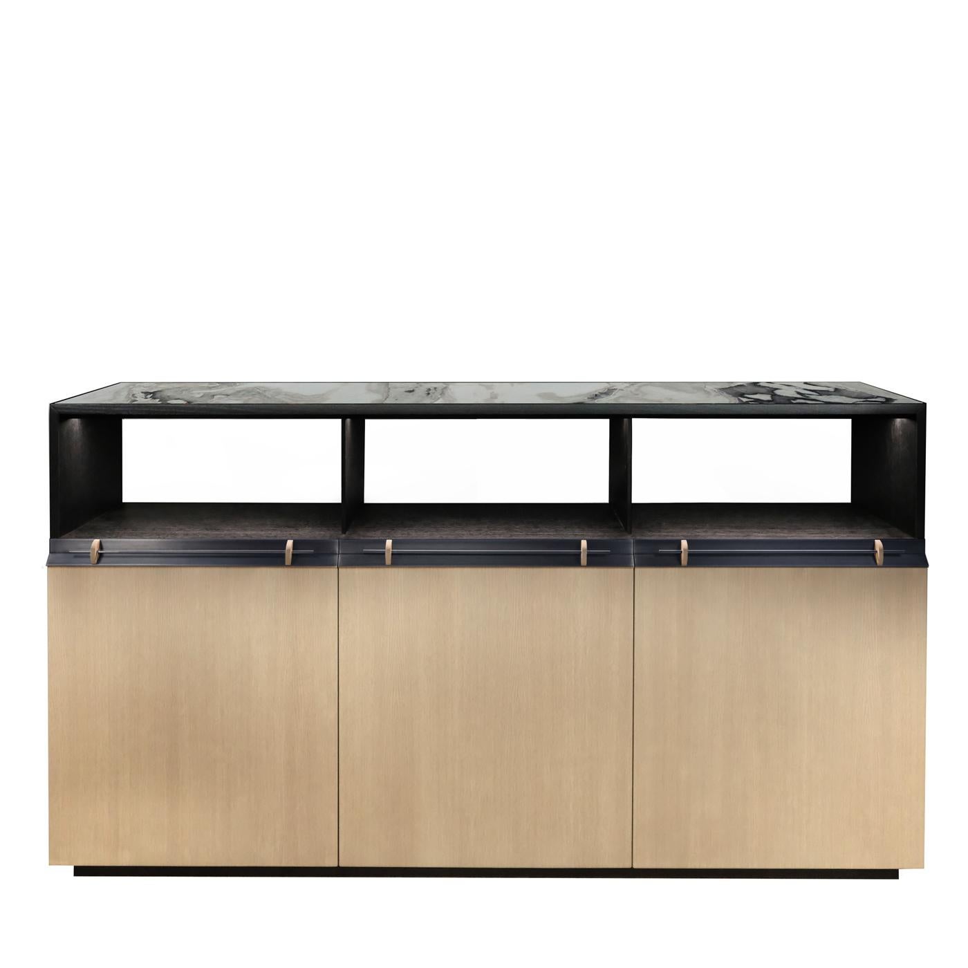 This sideboard is a versatile and eclectic piece of functional decor, combining refined materials and delicate finishes. Crafted of oak with a matte stained beige finish, it features three doors and corresponding upper open storage in black. The