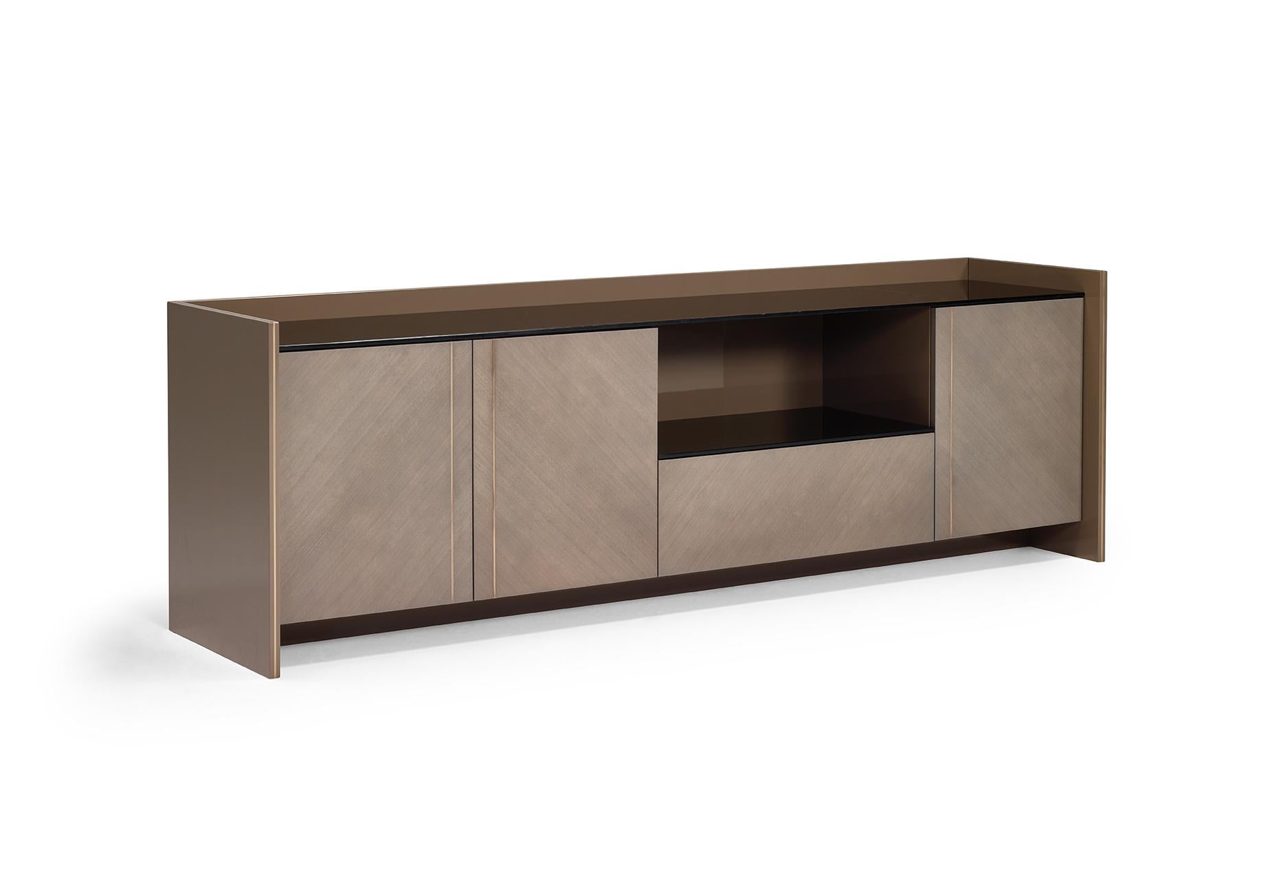 Exquisite brass details and sober-lines design combine in this eye-catching ASTAIRE sideboard. The embracing wooden structure and the doors can combine different finishes for an exclusive result. Astaire is composed by three doors and one deep