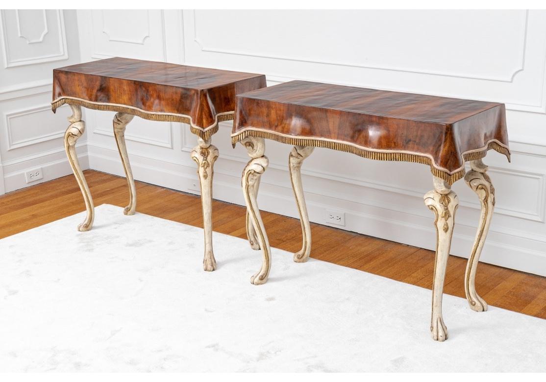 A Console table pair with rich and deeply colored Burl tops surmounting a French inspired Recurved and Sinuous Leg. Very well made Pair of Julia Gray Venetian Console tables featuring draped wood cloth motif top with hand painted accents on