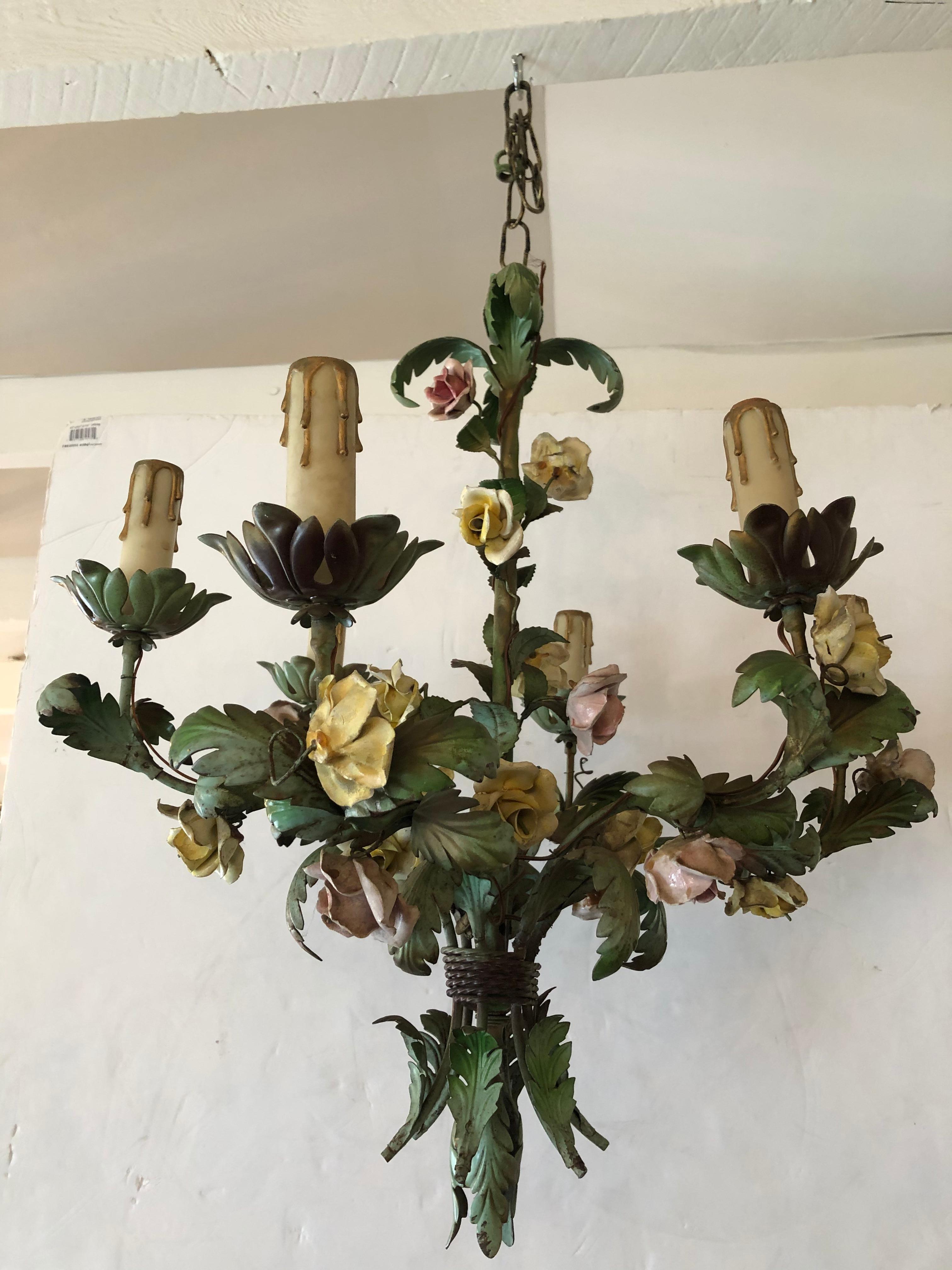 Romantic French painted iron and tole floral chandelier having muted pastel colors and porcelain flowers adorning 6 arms and drip candlesticks.

12
