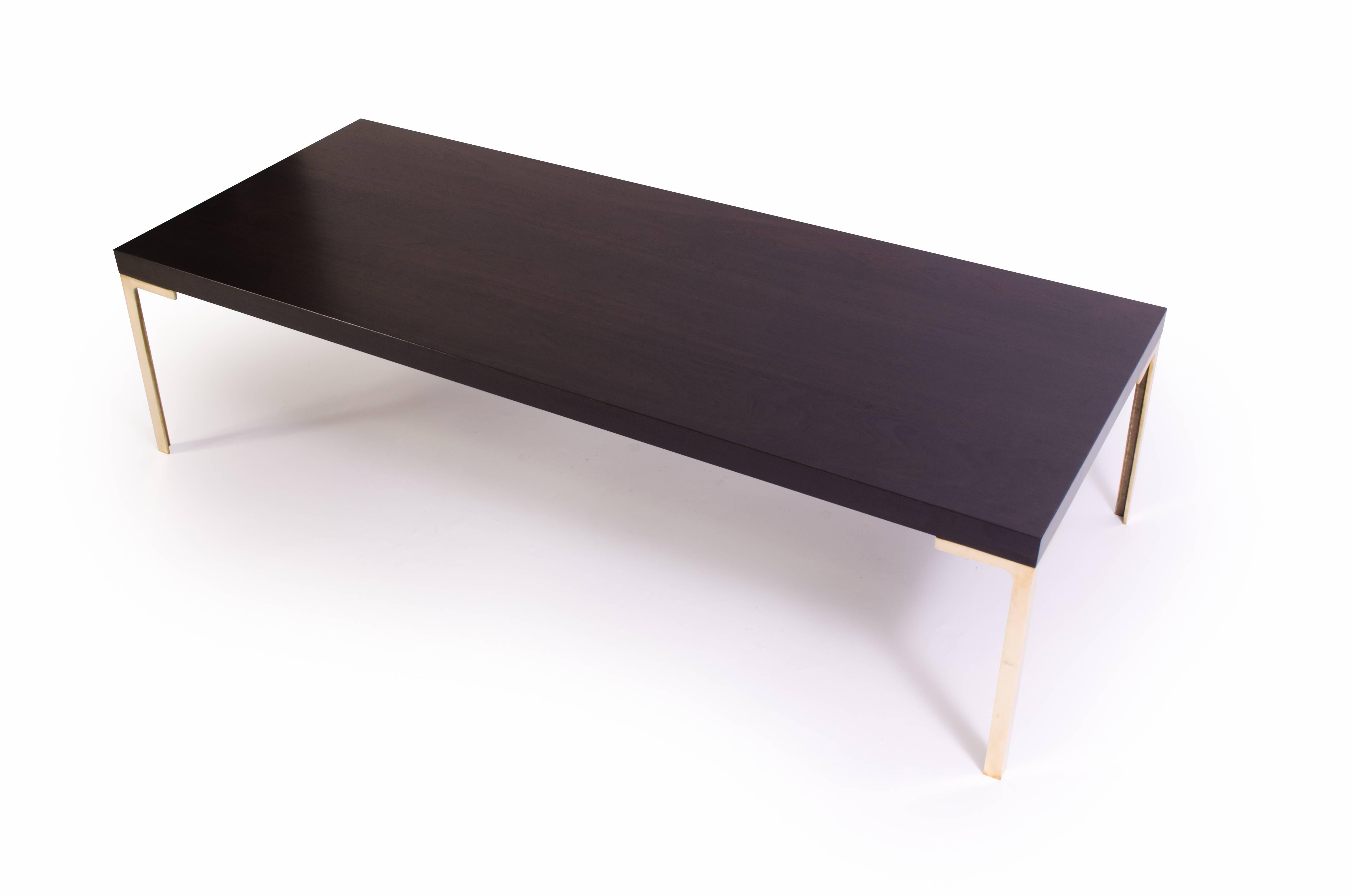 A stunning creation by Montage, the Astor cocktail table. This piece was designed with the Mid-Century in mind embodying delicate proportions and bold use of the highest quality materials. 

The table is topped with solid ebonized walnut, the stain