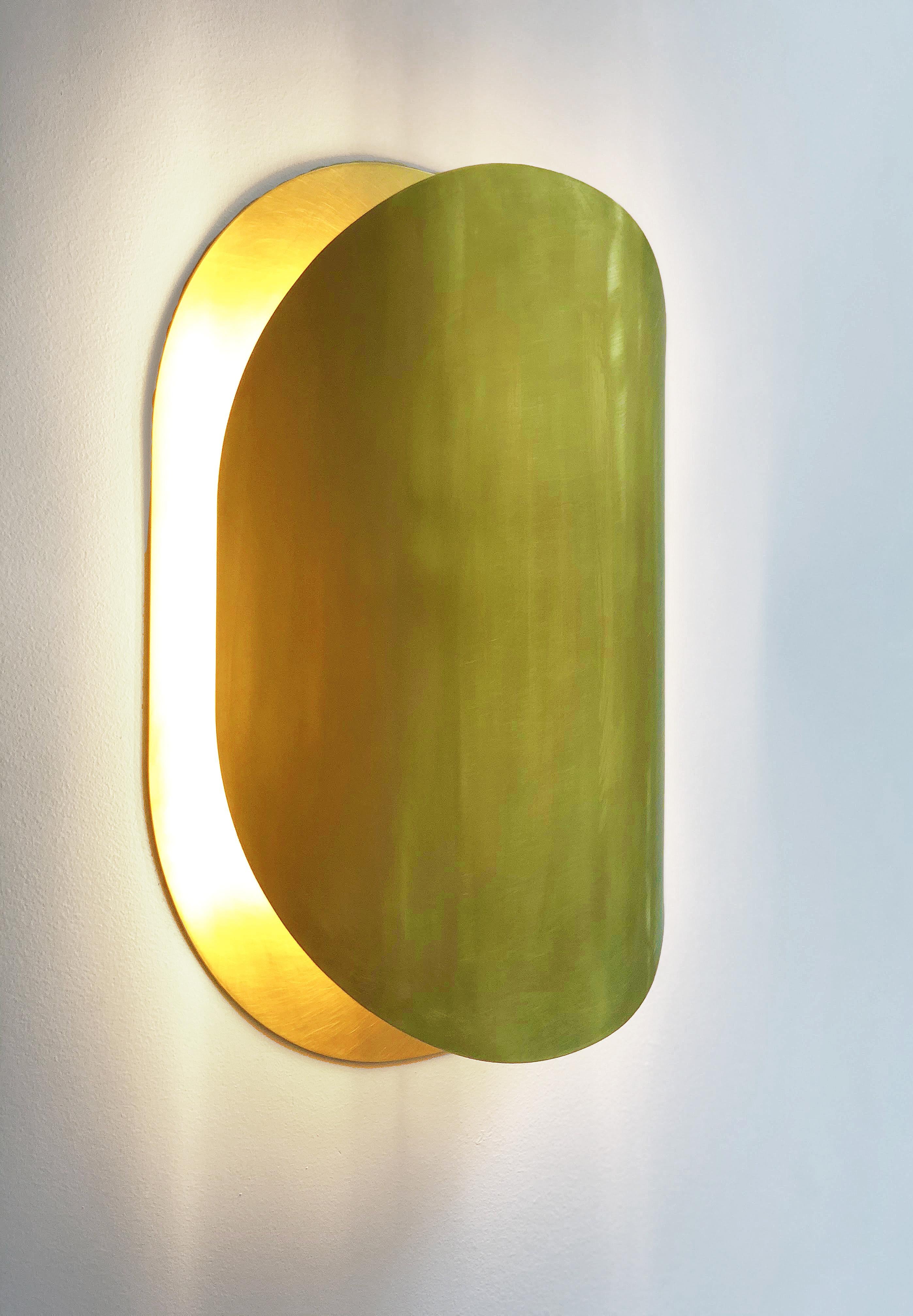 The Astra sconce light is the result of research to create a warm and vibrant yet ecological light. 
It recalls the mesmerizing effect of a lunar eclipse, playing around simple shapes to capture
interesting lighting effects. The curved brass