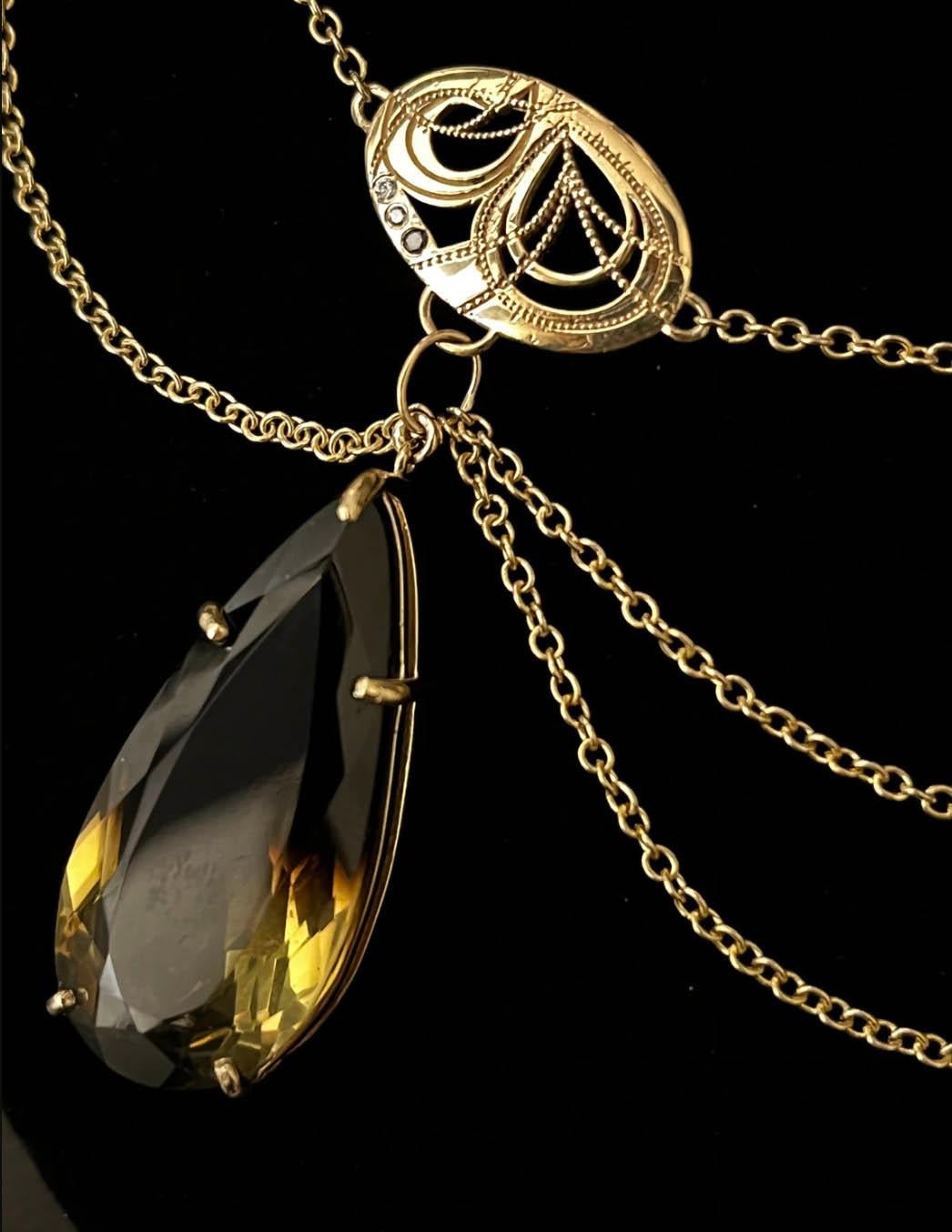 ASTRA 
OUR ASPIRATIONS WILL TAKE US TO THE STARS
A custom cut 35.5 carat pear citrine is suspended from strands of shimmering gold chain and hand engraved celestial pendants. Cascades of black, white, and champagne diamonds sparkle throughout this