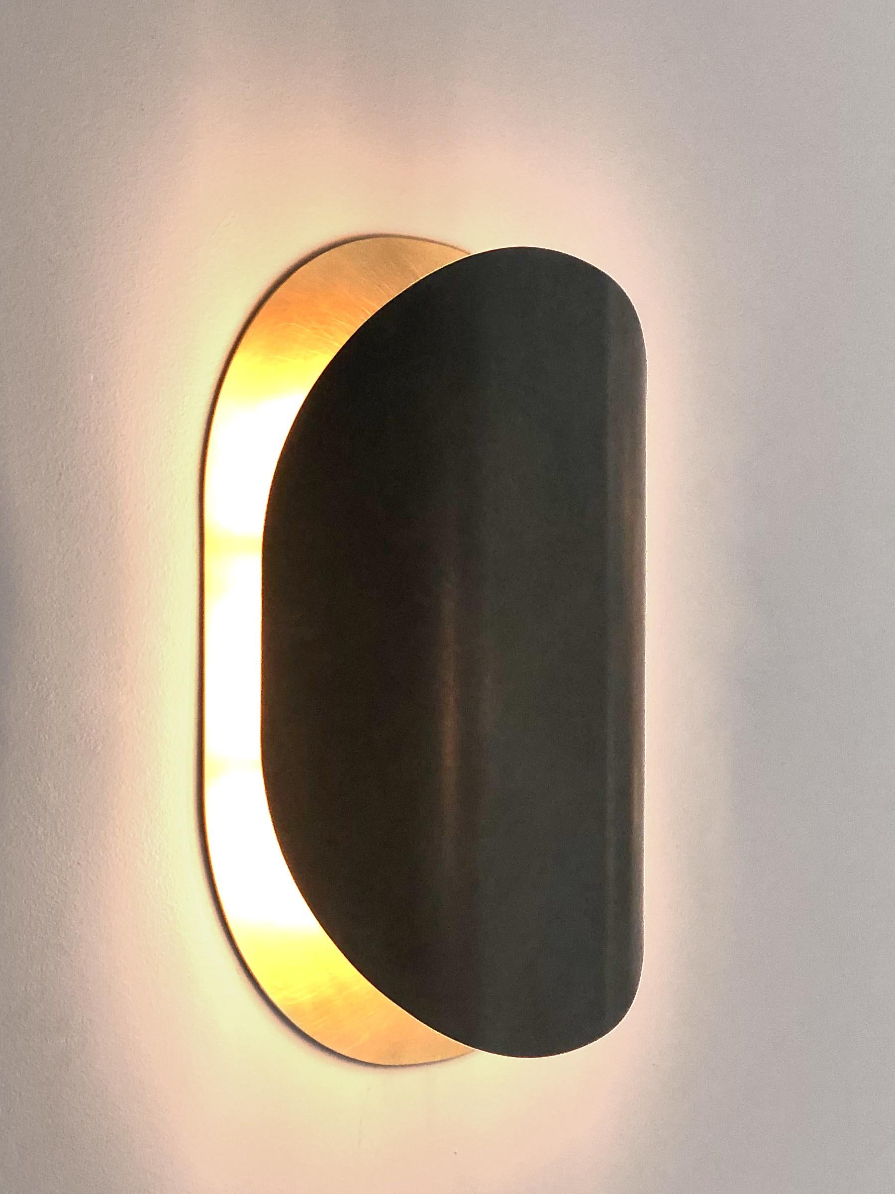 Astra wall light is presented by Victoria Magniant for Galerie V

The new Astra wall lamp evokes the light effects of an eclipse. Patina work is applied to the exterior of the wall-light to provide an effect of contrast. The invisible assembly