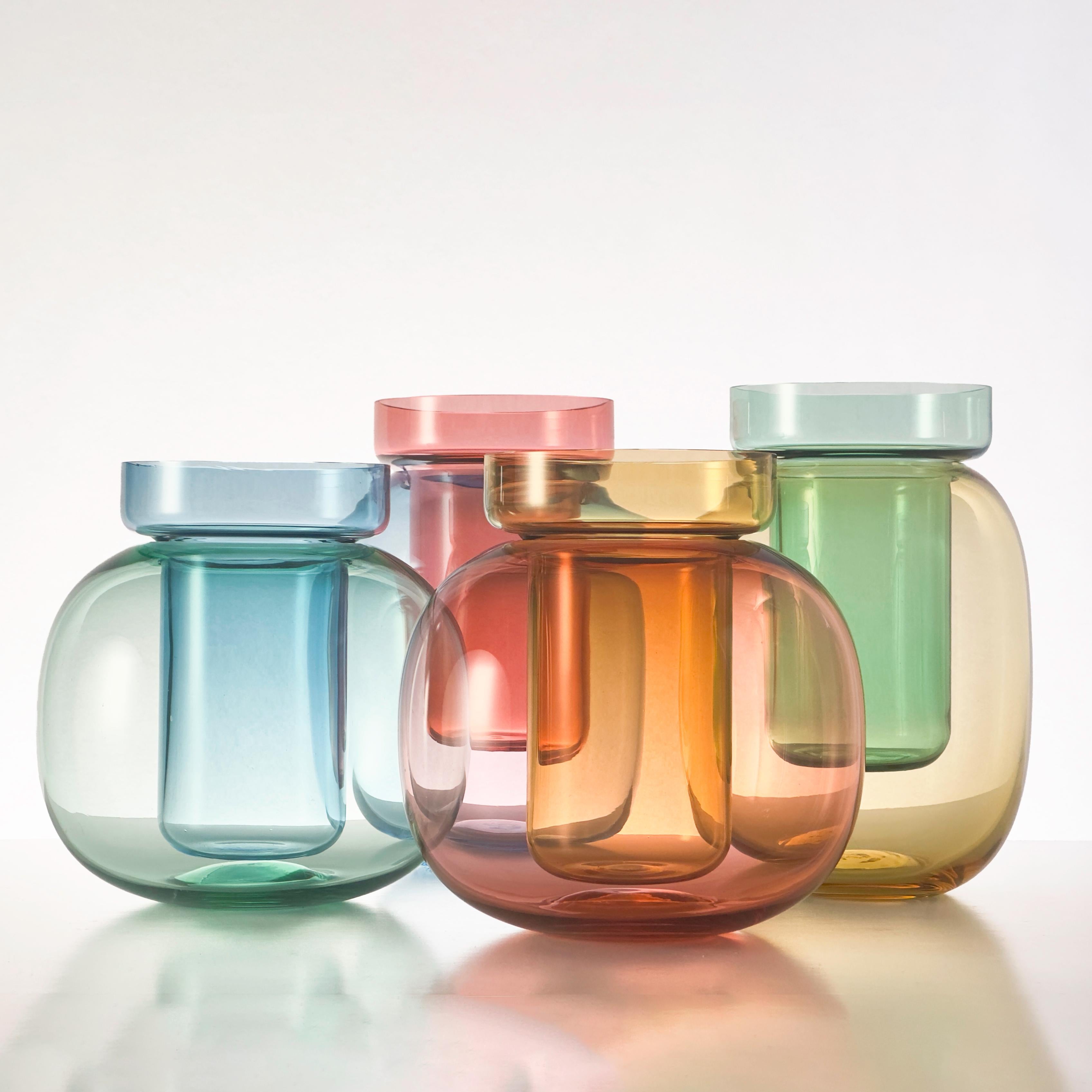 Astral Vase è un vaso in vetro soffiato a mano composto da due componenti contrastanti e saturi di colore che, se combinati, producono una terza tonalità. La forma esterna arrotondata sostiene un componente interno più lineare, elevandolo al di