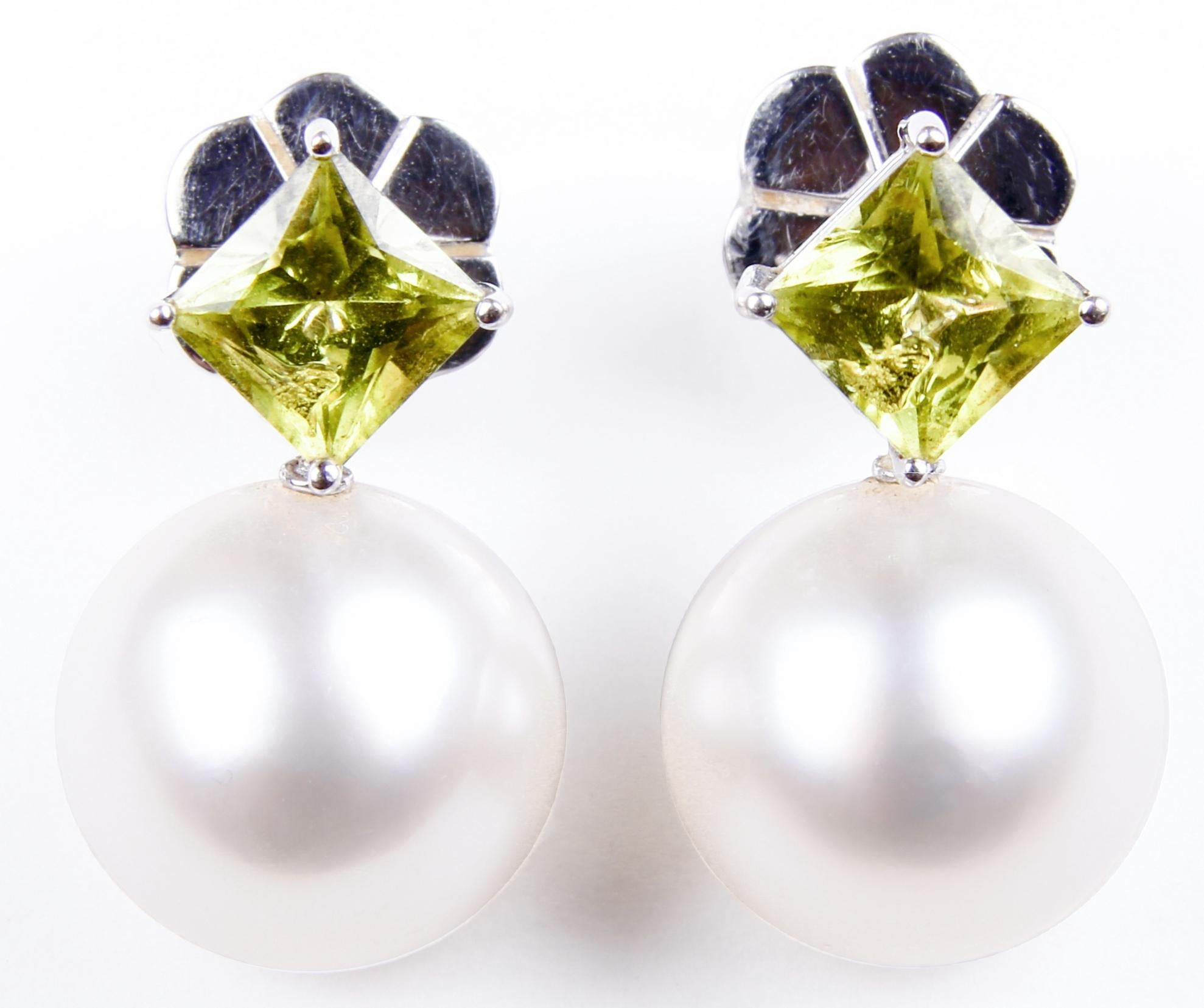This is a stunning pair of earrings created by the exclusive award winning Australian jewellers Autore. The earrings each feature a cultured South Sea pearl and a green peridot. The metal is 18 karat white gold, as signified by the 750 stamp on the