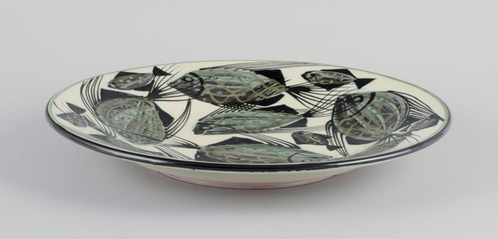 Pre-owned goods are exempt from import duties for U.S. customers. 
Therefore, no import tariffs will be applicable to your purchase.

Astrid Tjalk for Kähler.
Large ceramic dish. Hand-glazed.
Glaze in green and black colours on a cream-colored