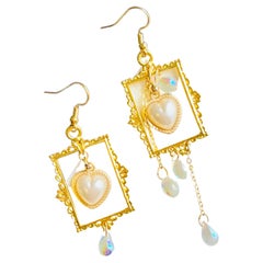 Boucles d'oreilles asymétriques baroques avec pompons, cadre rectangulaire, cœur, perles et gouttes d'eau.