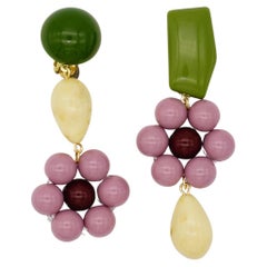 Boucles d'oreilles asymétriques avec pendentif en forme de goutte d'eau en forme de fleur violette, verte et beige.
