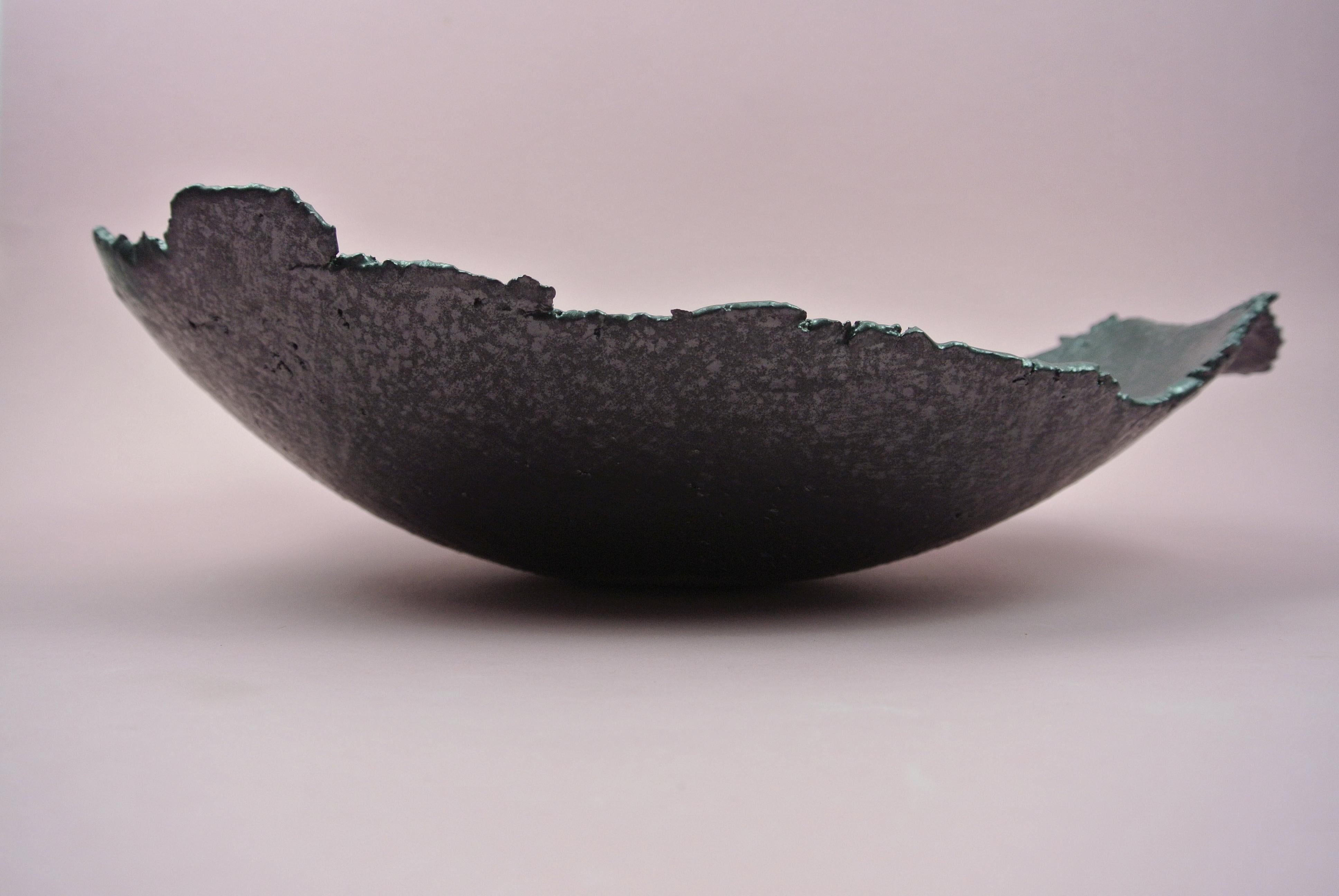 Rough stoneware bowl with visible fire sand texture on surface.
Extreme elongated asymmetric shape and black metallic glaze with a irregular appearance.
Food proof.