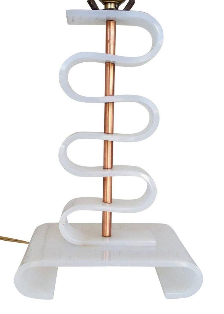 This wild table lamp exhibits an experimental post-war Mid-century aesthetic with its undulating curves of white acrylic, connected to a brass cylinder and mounted to a shaped acrylic base.
