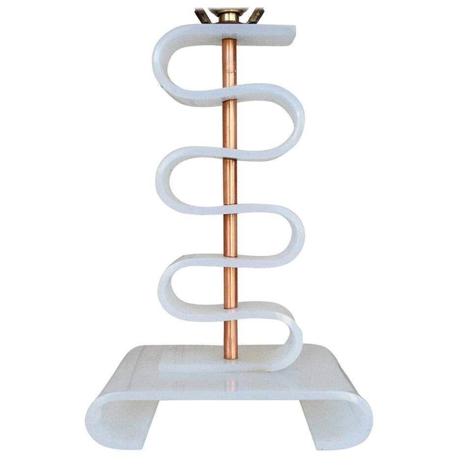 This wild table lamp exhibits an experimental post-war Mid-century aesthetic with its undulating curves of white acrylic, connected to a brass cylinder and mounted to a shaped acrylic base.