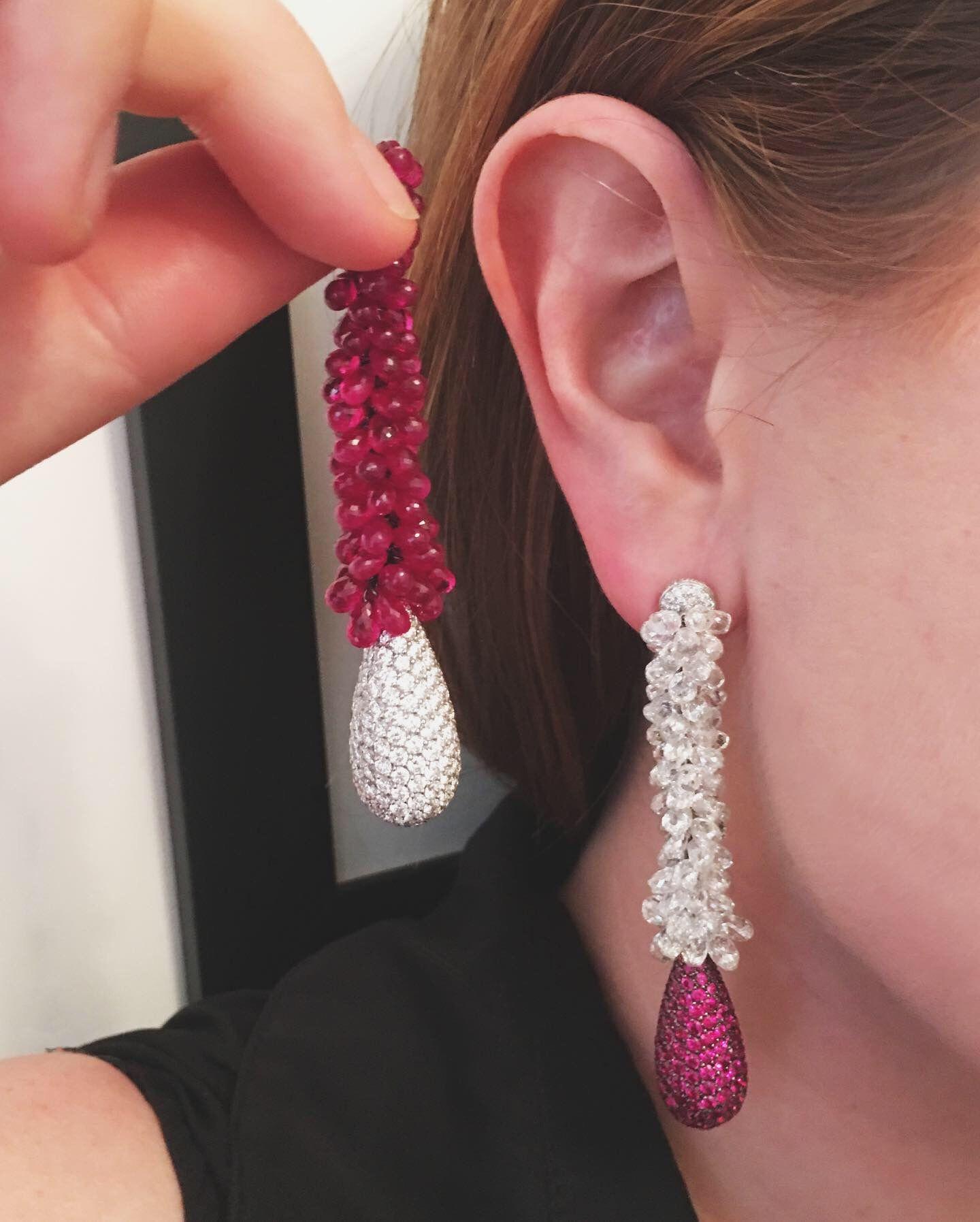 Pair of contemporary pendant earrings of asymmetric design, each earring features a cluster of 81 briolette-cut diamonds or rubies terminating with a white gold teardrop set with 236 pave rubies or diamonds. Total weight of rubies 100 carats,