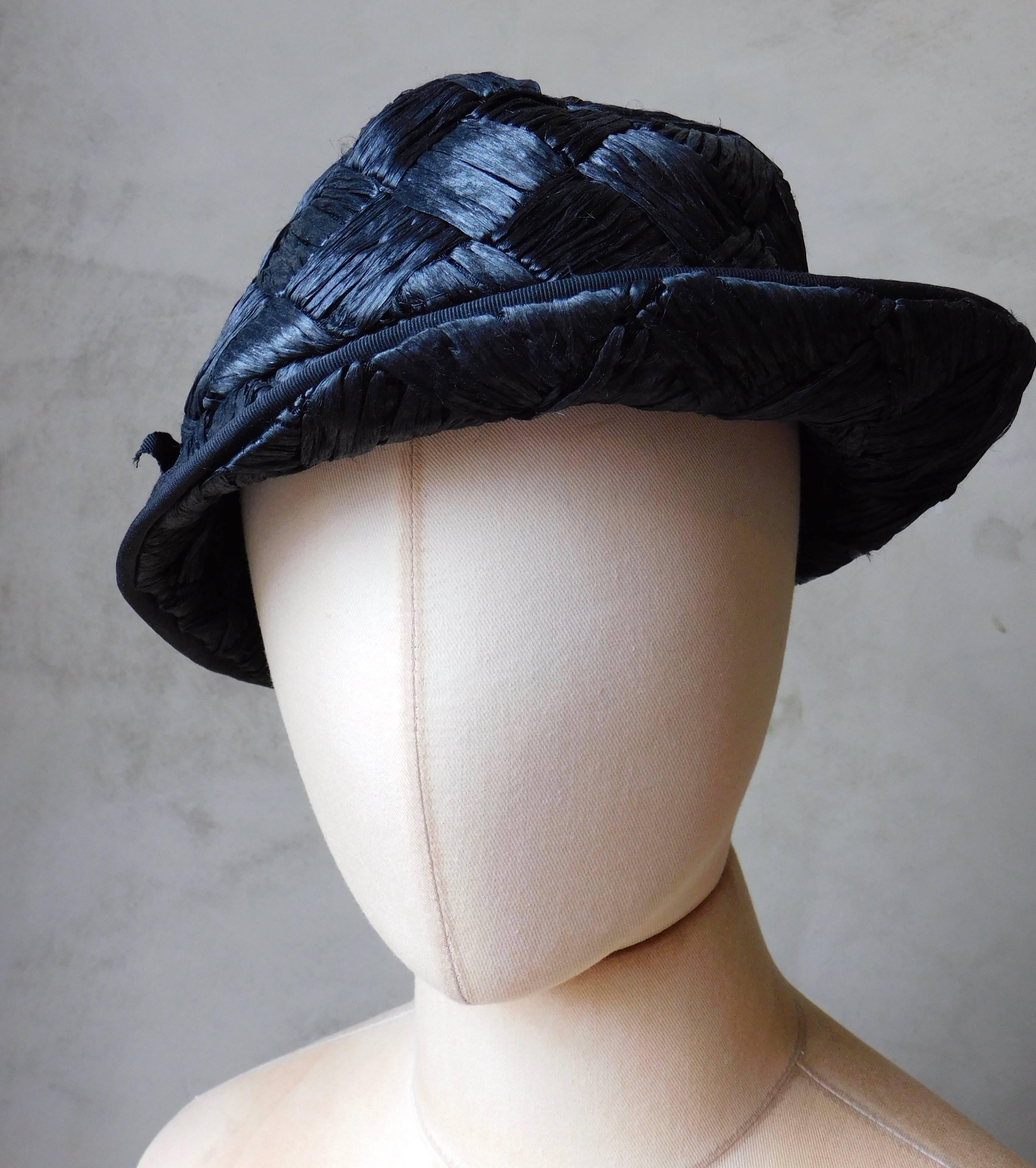 Very chic French 1940's woven straw hat in an asymmetrical design. Woven from black raffia  and trimmed with black grosgrain ribbon .
Fits a regular size head 
size 56cm(22