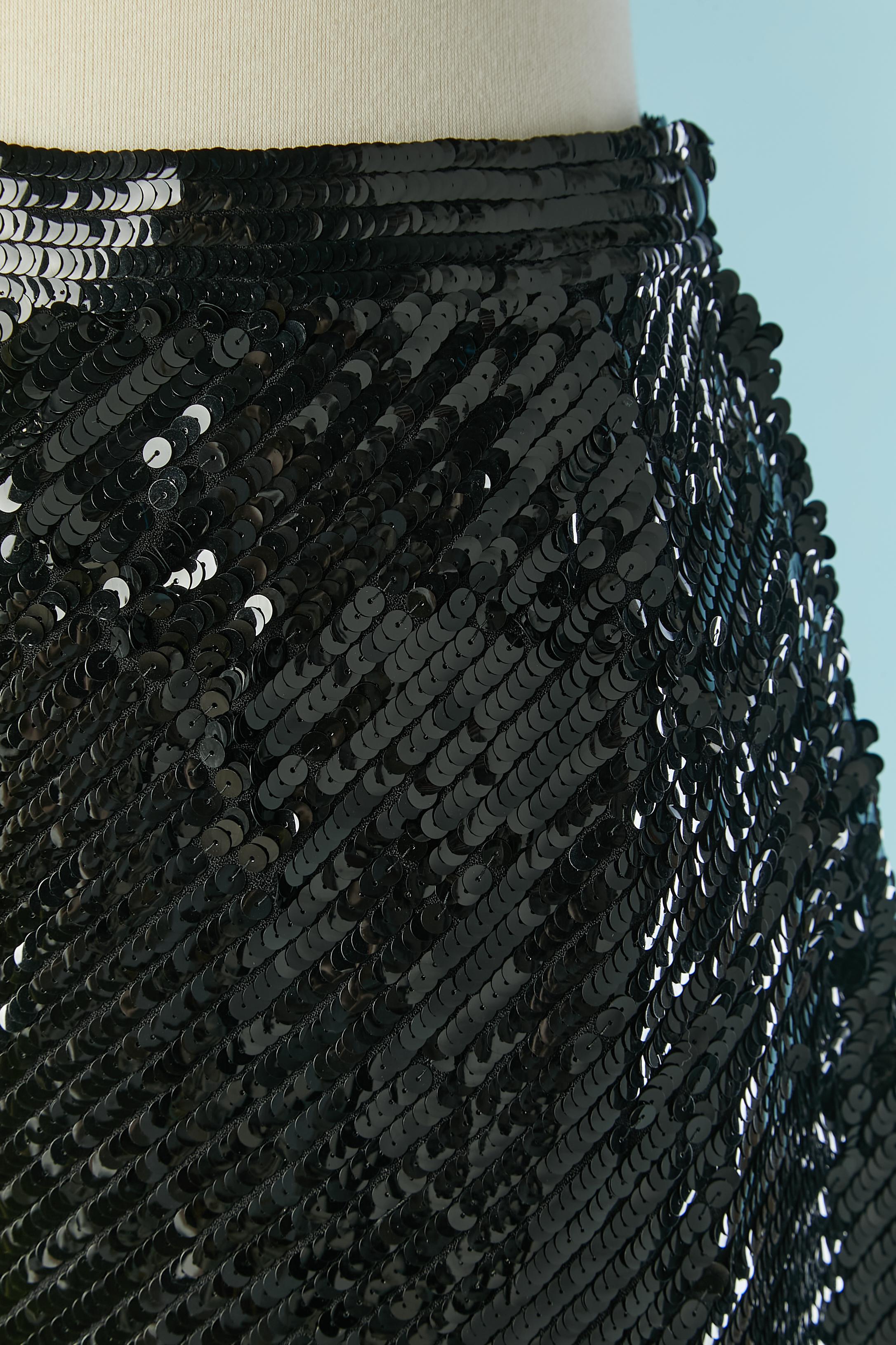 Asymmetrical black sequin skirt. Main fabric composition: 50% acetate, 50% rayon. No indication for the lining composition but probably acetate or rayon. 
Black button, buttonhole and zip closure on the left side. 
Shorter lenght = 45cm
Longer