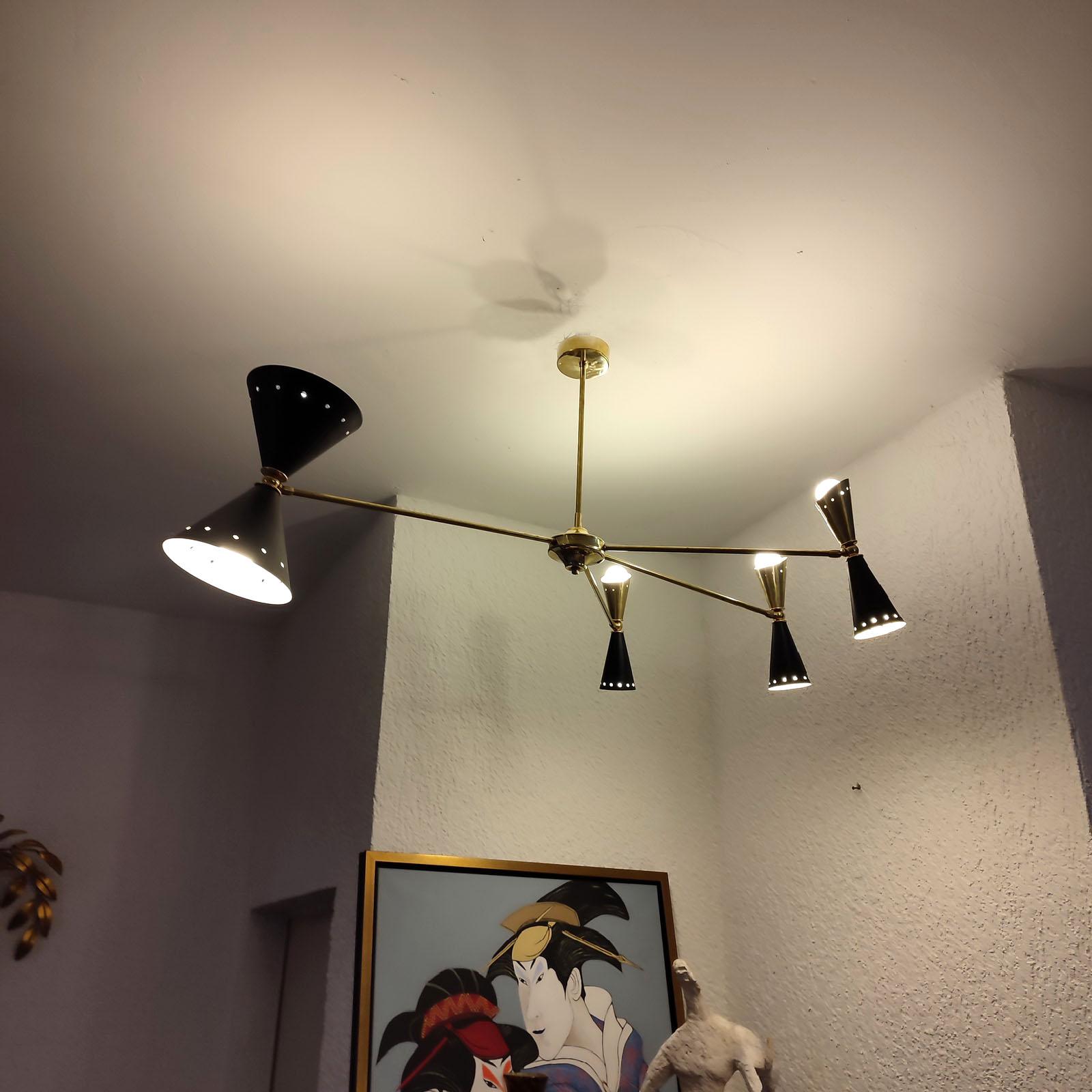Lampadario asimmetrico italiano, realizzato in ottone e metallo laccato, con paralumi orientabili. Dotato di 4 faretti superiori + 4 faretti inferiori, con circuiti separati. Basi E14. Funziona anche negli Stati Uniti con lampadine E14 a 110V: